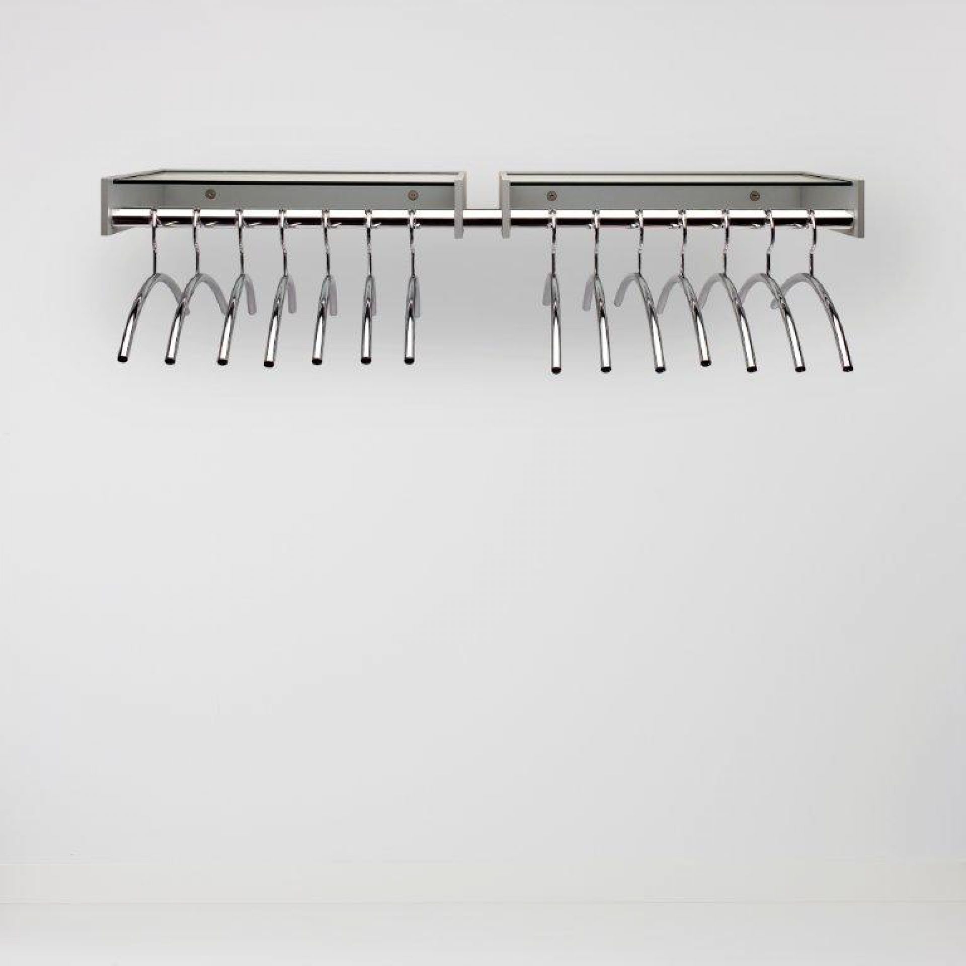 Hangon Wandgarderobe von Cascando mit Chrom-Kleiderbügeln an einer grauen Wand.