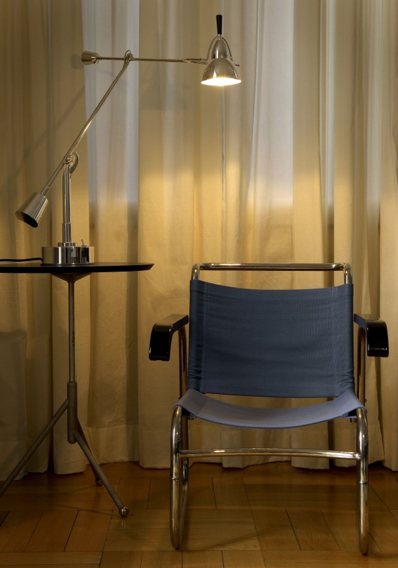 EB 27 Tischleuchte von Tecnolumen: Verstellbare Schreibtischlampe aus Metall auf einem kleinen Tisch.