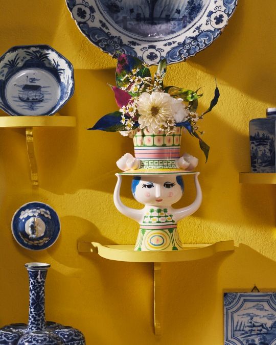 Dekorative Bjorn Wiinblad Lady with Hat Vase, 24,5 cm hoch, mit Blumen auf gelbem Hintergrund.