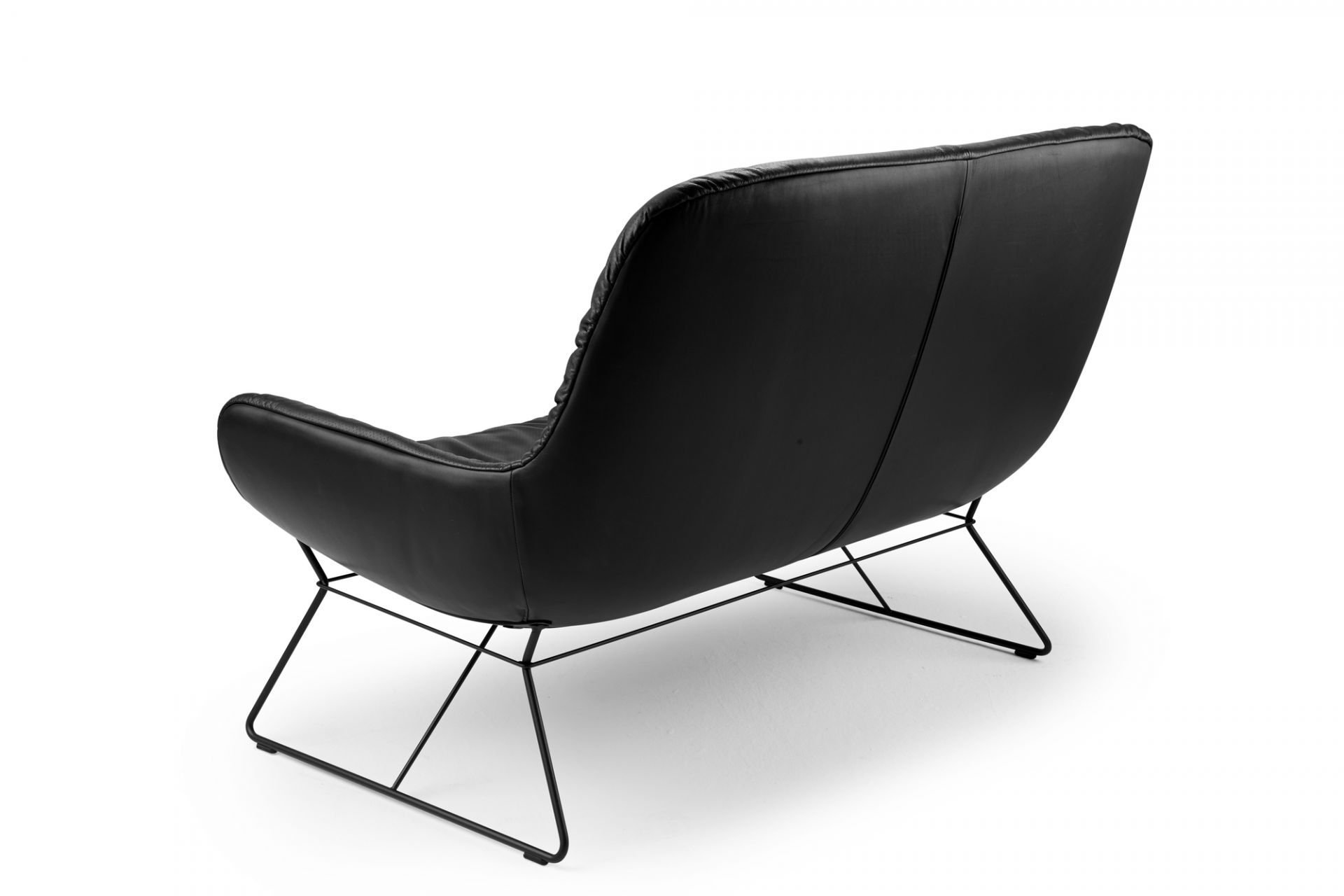 Schwarze Leya Loungecouch der Freifrau Manufaktur, Rückansicht mit filigranem, schwarzem Metallgestell auf weißem Hintergrund.