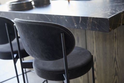 Nahaufnahme eines grauen Verpan Series 430 Barhockers mit schwarzem Metallgestell an einer Küchentheke.