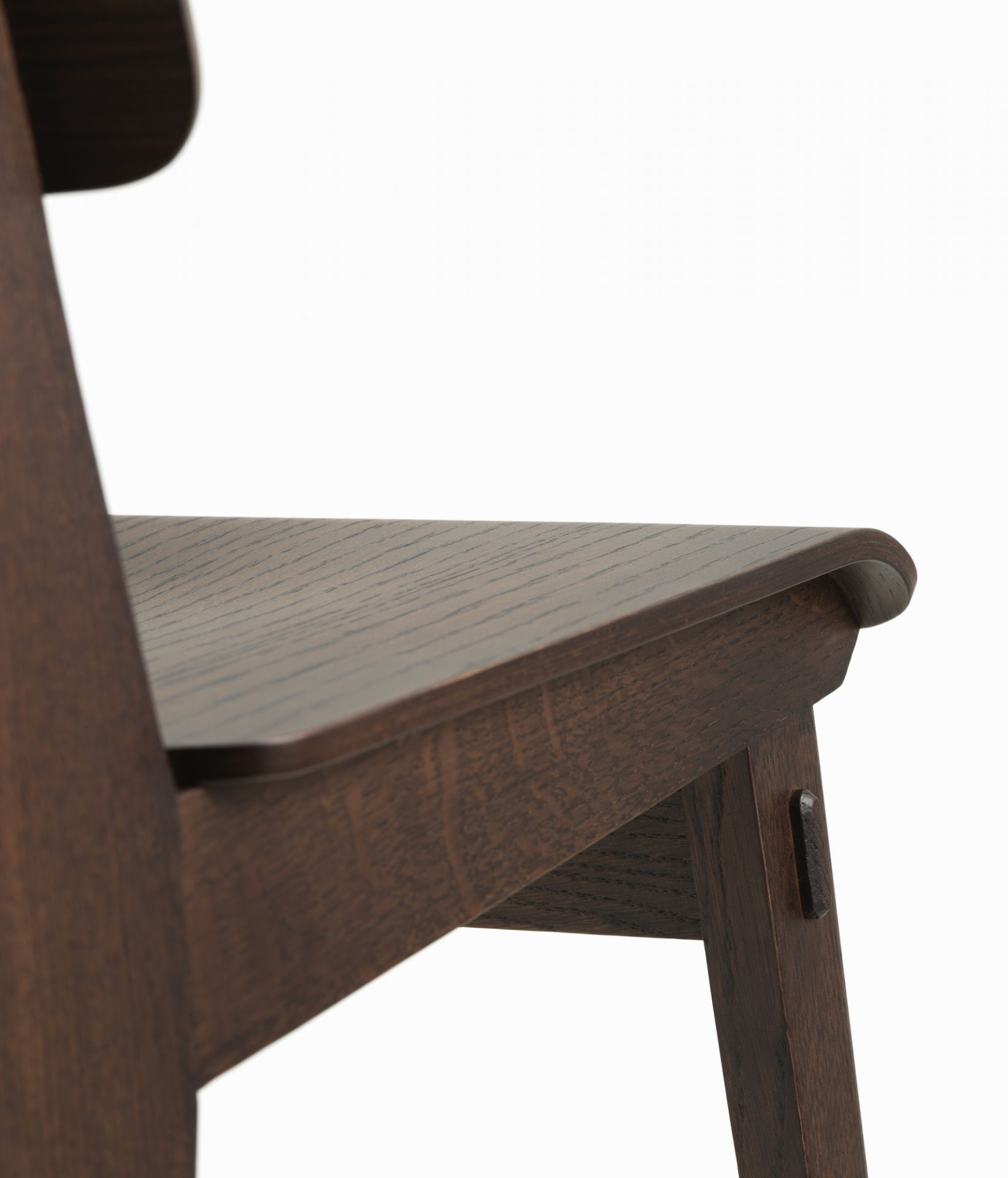 Detailaufnahme des Vitra Chaise Tout Bois Stuhls: Dunkles Holz, Sitzfläche und Stuhlbein mit markanter Holzmaserung.