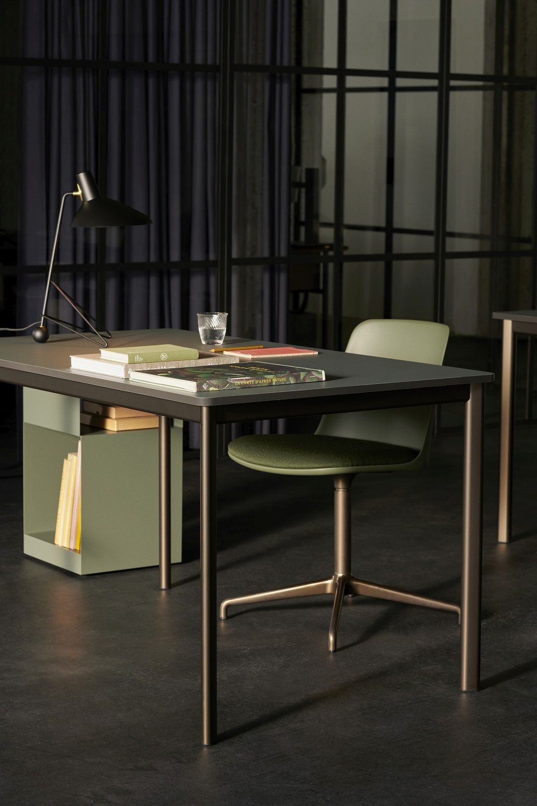 AndTradition Tripod HM9 Tischleuchte auf Schreibtisch mit Büchern und Stuhl im modernen Büro.