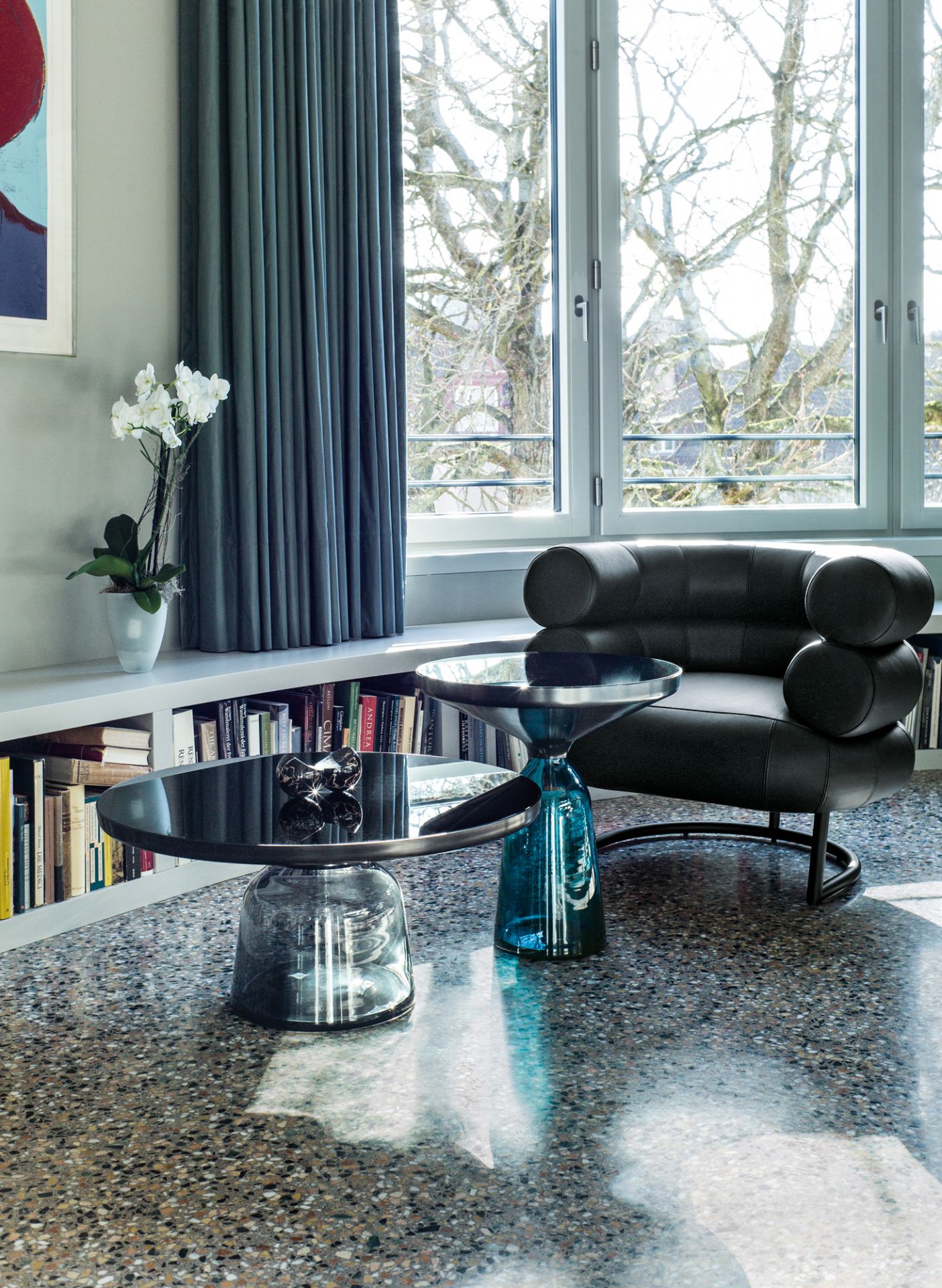 Bell Coffee Table von ClassiCon: Couchtisch mit runder, schwarzer Glasplatte und blauem Glasfuß im Wohnzimmer.