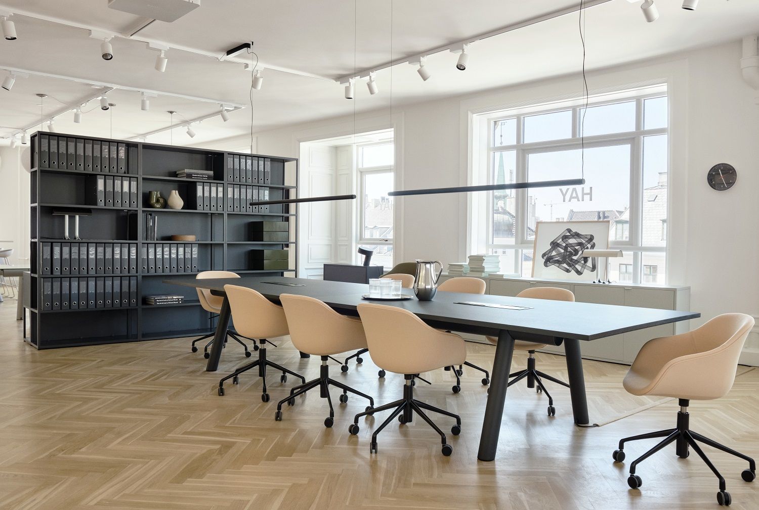 Heller Konferenzraum mit langem, schwarzem Boa Table Tisch von Hay und beigen Bürostühlen.