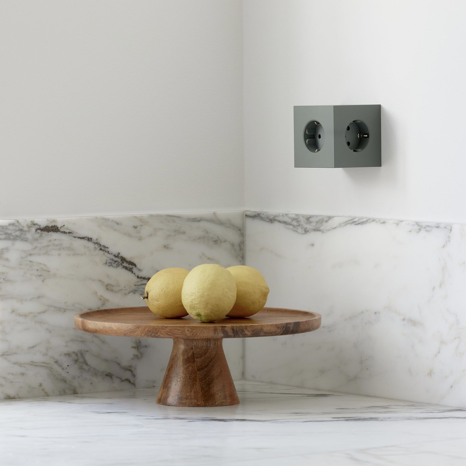 Grüner Avolt Square 2 Steckdosenwürfel mit USB-C an der Wand, Zitronen auf Holztablett.