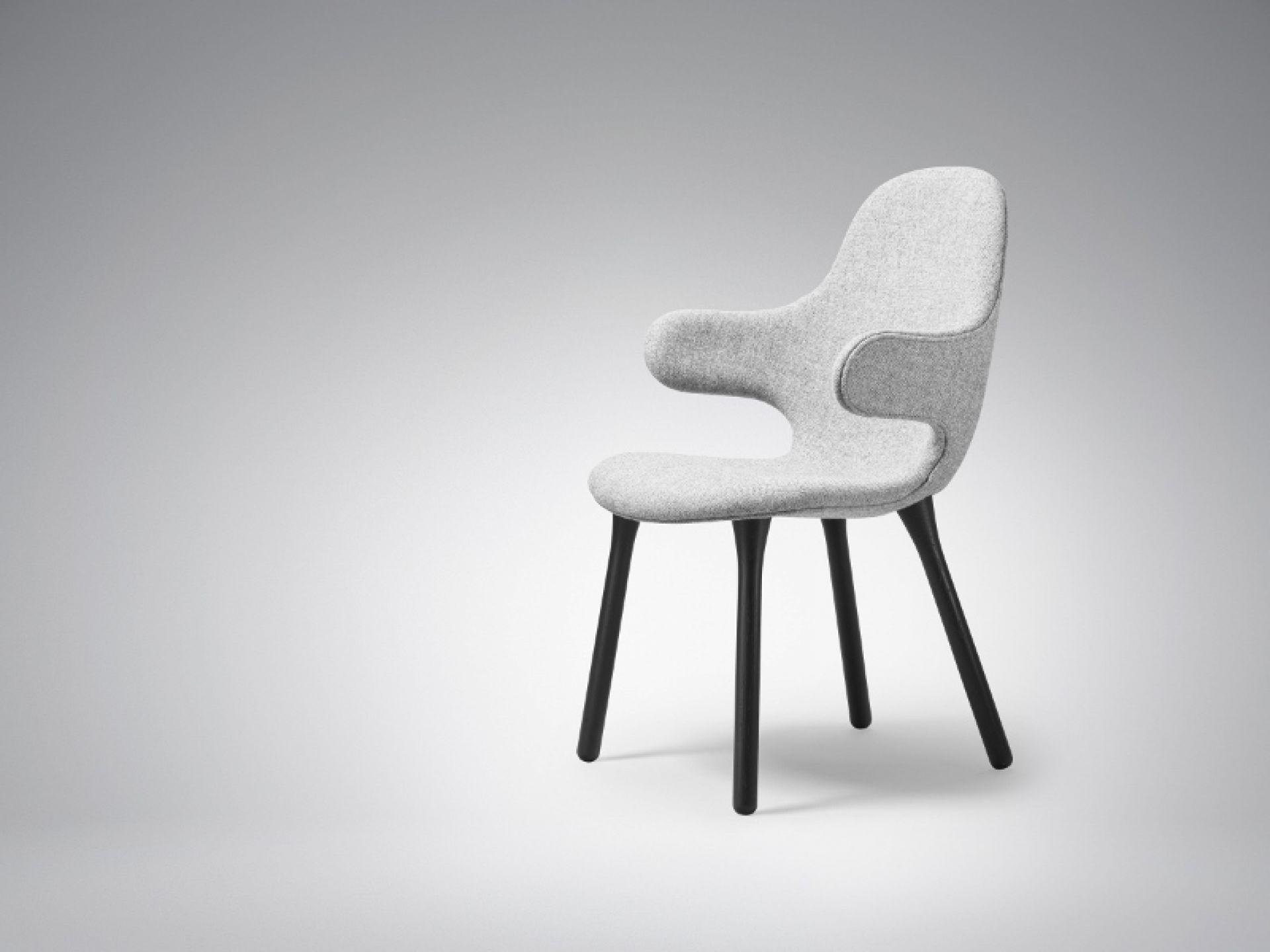 AndTradition Catch Chair JH1 Stuhl, hellgrauer Stoffbezug mit schwarzen Holzbeinen, modernes Möbeldesign.
