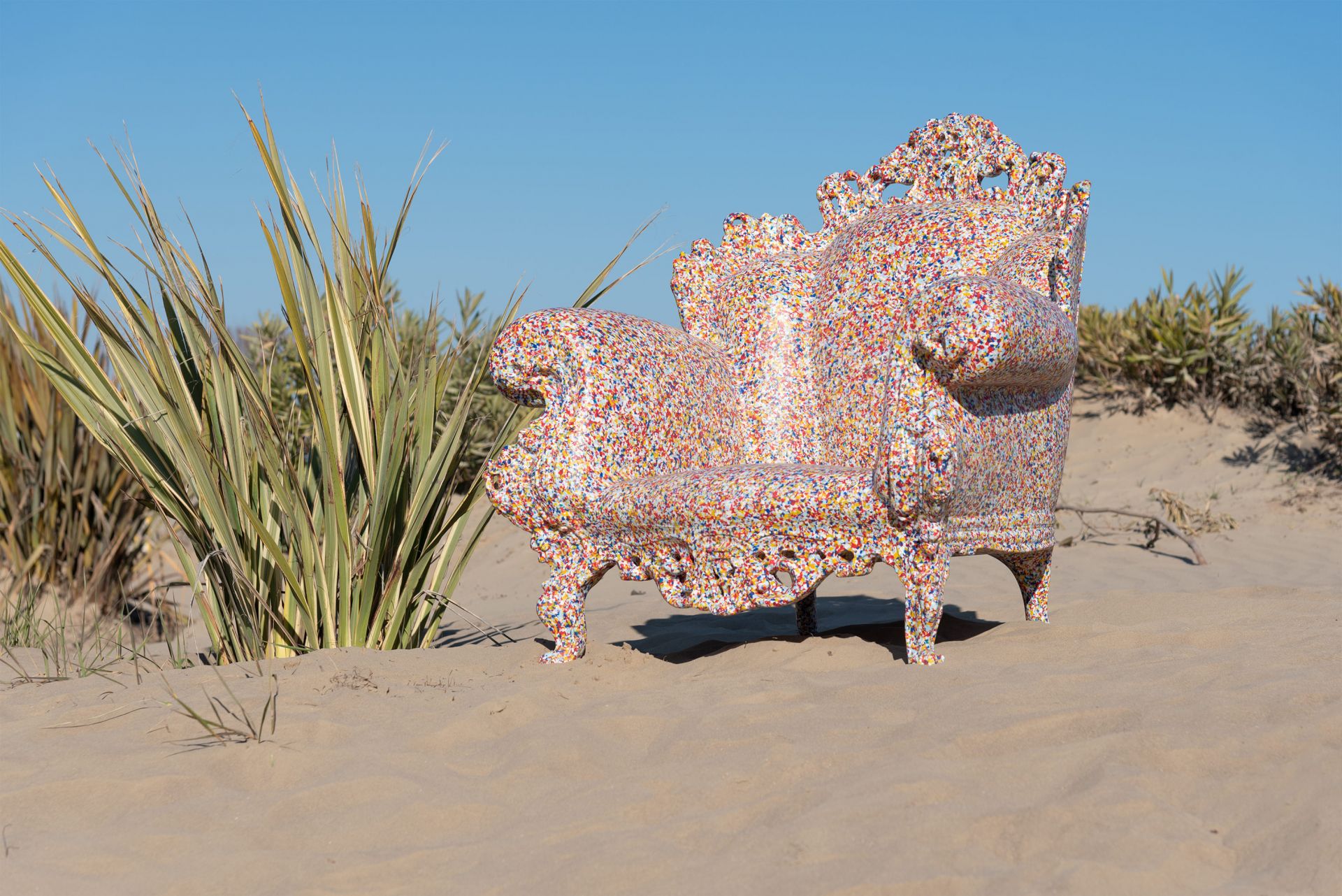 Farbenfroher Proust Sessel Outdoor von Magis auf Sandstrand mit blauem Himmel, Gartenmöbel und Design.