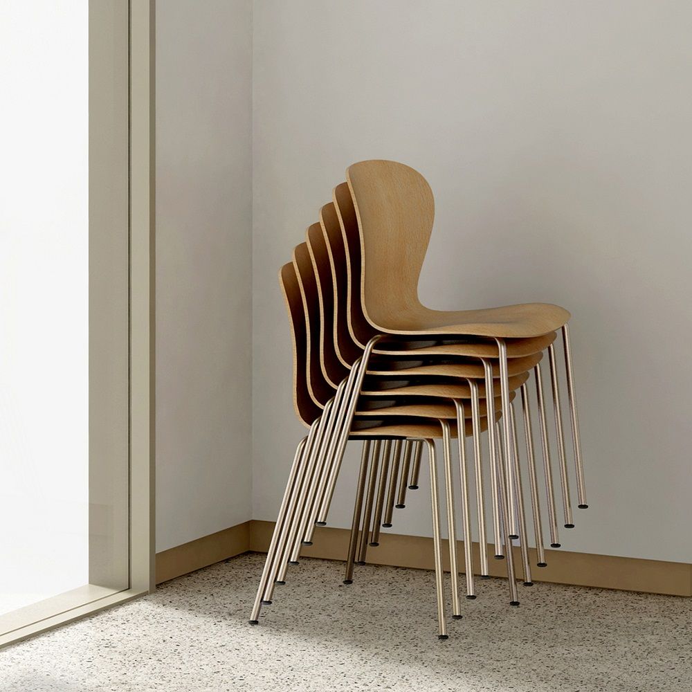 Stapel aus fünf Thonet S 220 Formholzstühlen ohne Armlehne mit verchromten Stahlrohrgestell vor einer weißen Wand.