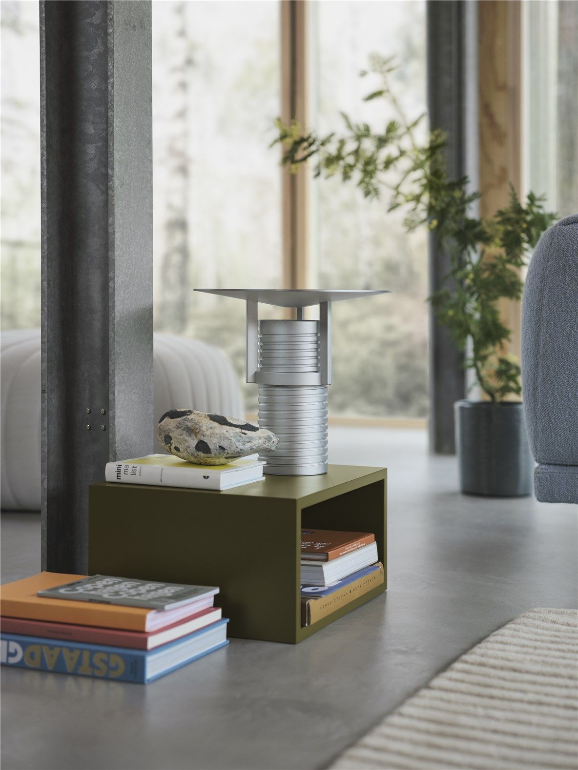 Muuto Set Table Lamp Tischleuchte in Silber auf einem grünen Nachttisch mit Büchern.