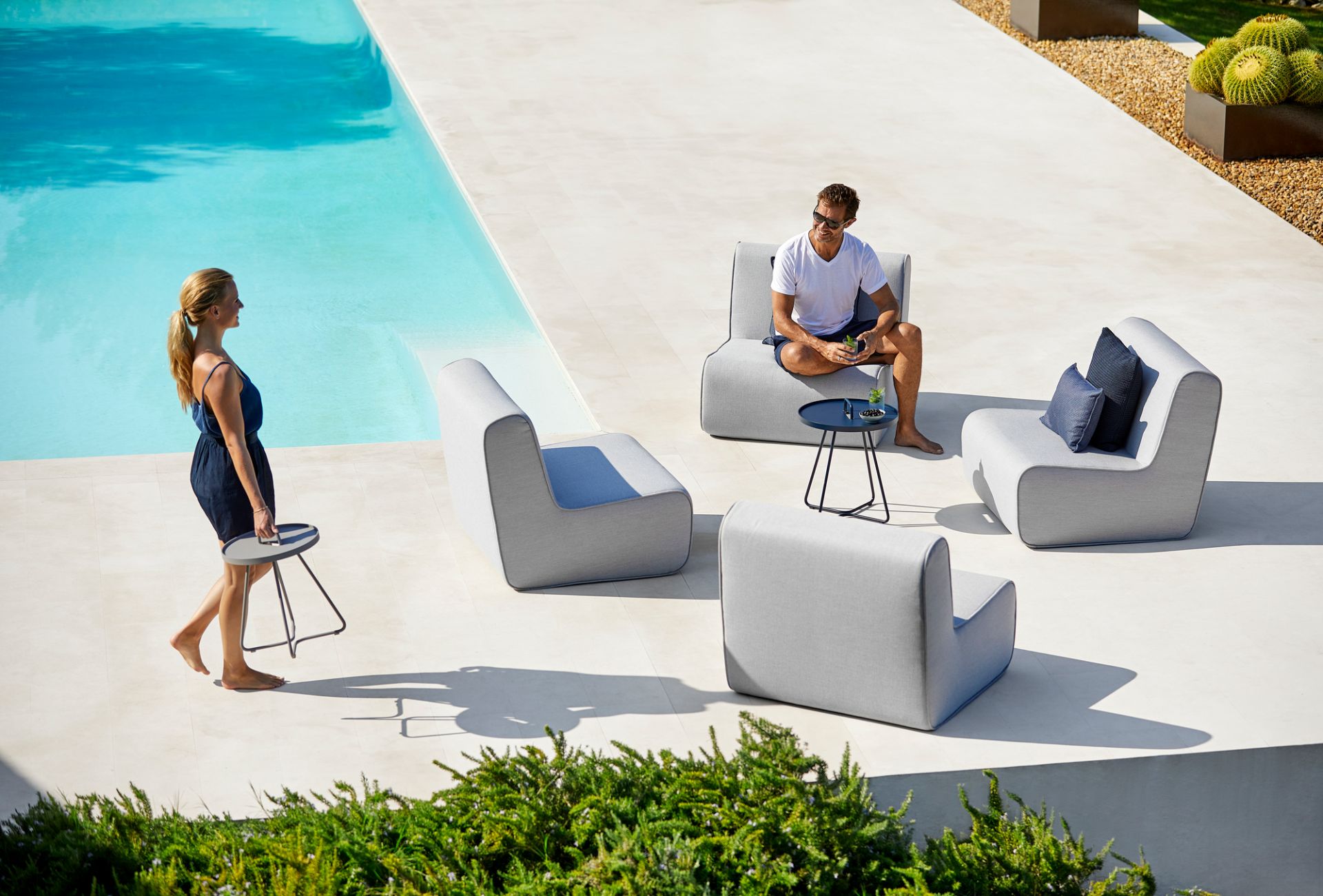 Szene mit Cane-Line Outdoor Möbeln: Lounge Sessel und On-The-Move Beistelltisch in Schwarz.