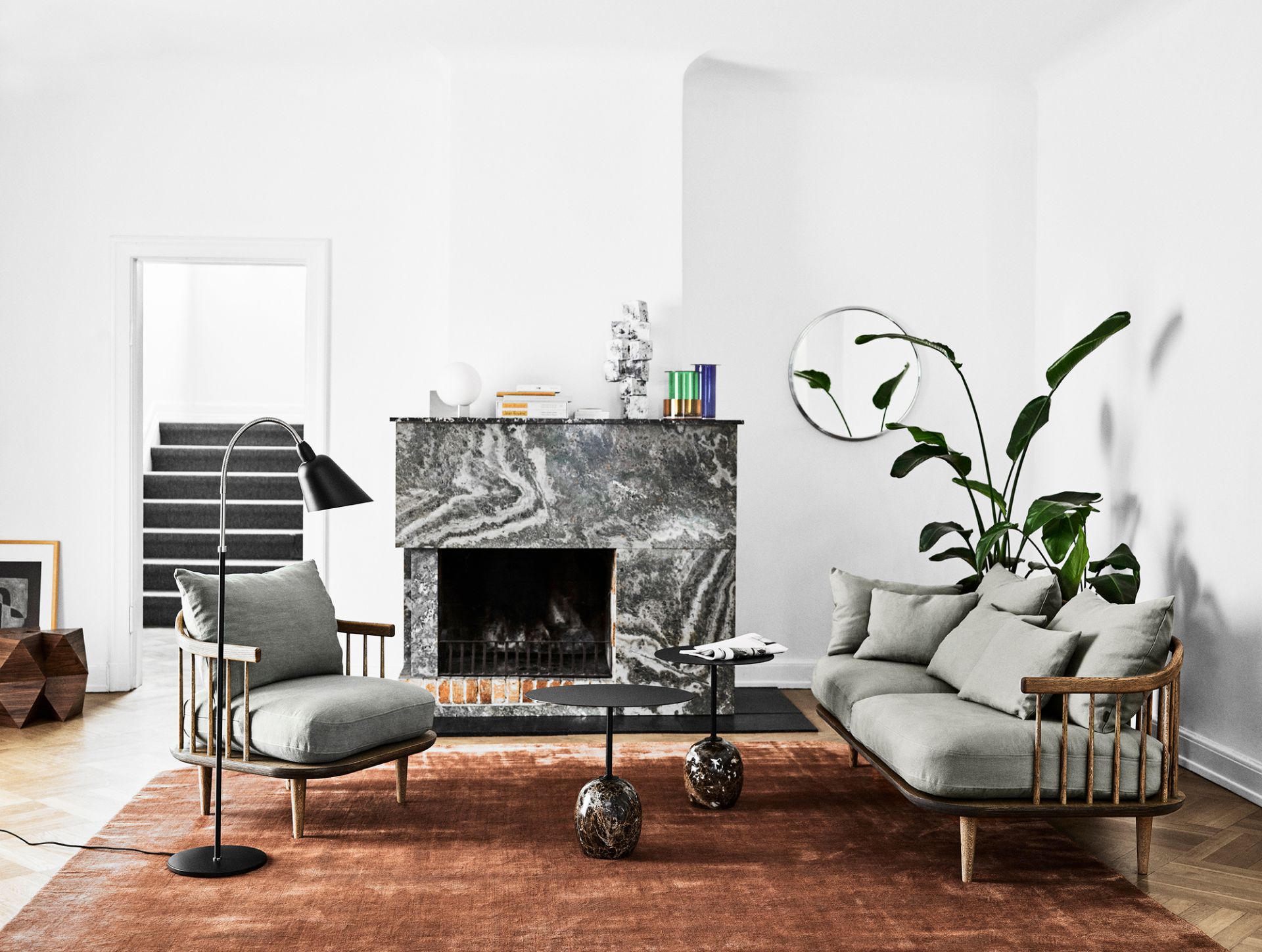 AndTradition Bellevue AJ7 Stehleuchte in stilvollem Wohnzimmer mit Sessel, Sofa, Marmorkamin und braunem Teppich.
