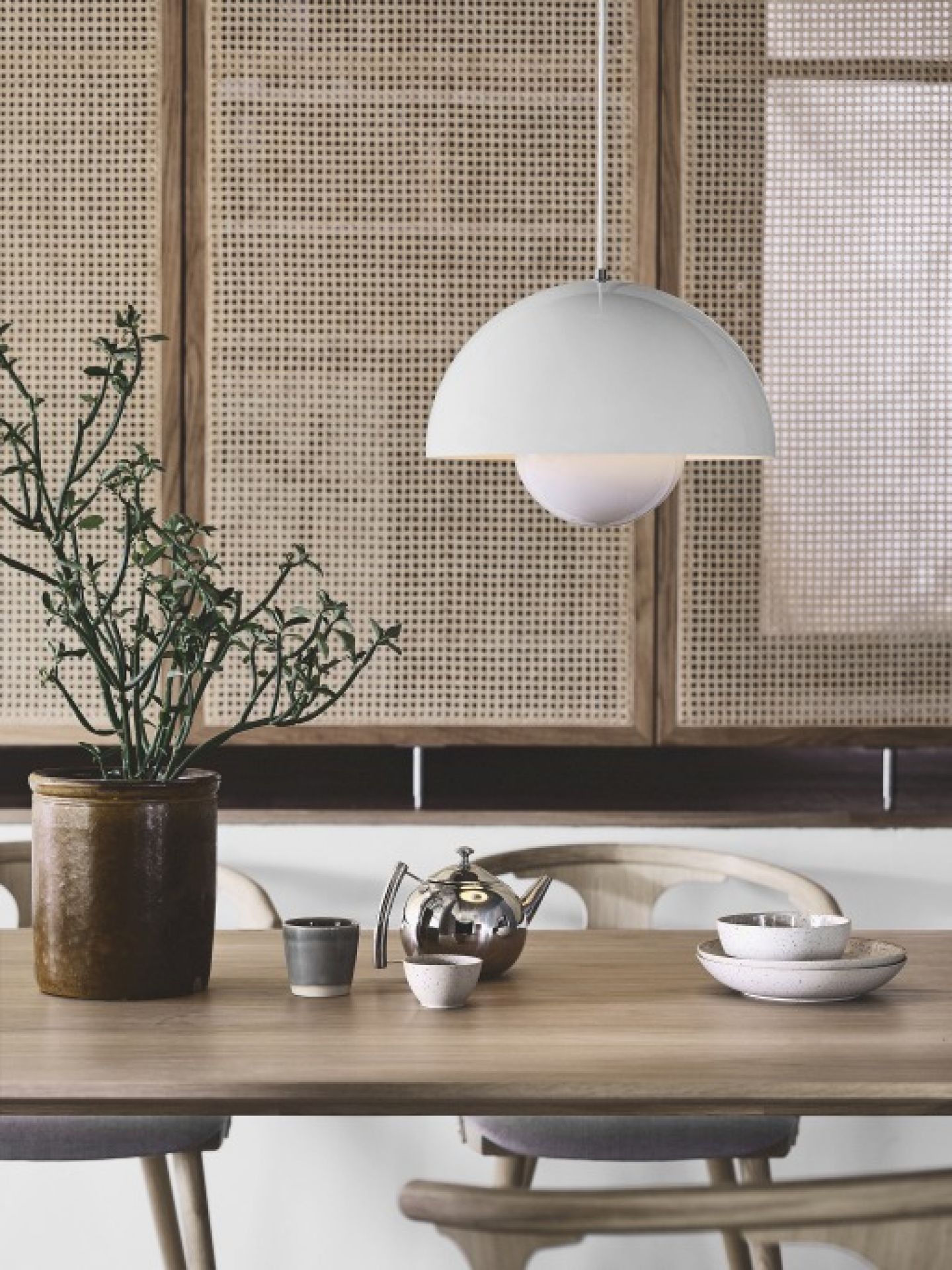 Weiße Flowerpot Pendelleuchte von AndTradition über Esstisch mit Teekanne und Geschirr. Design Lampe.