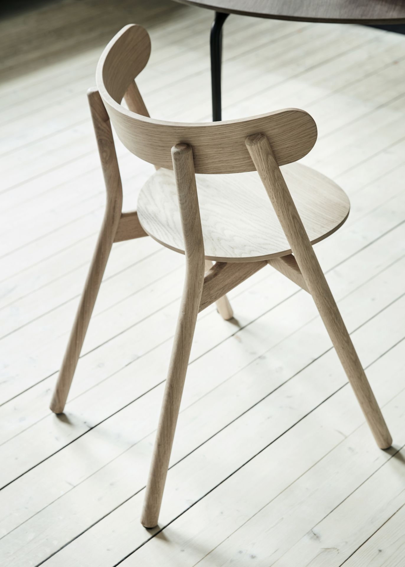 Oaki Stuhl aus Eiche Northern: Rückansicht des hellen Holzstuhls mit runder Sitzfläche.