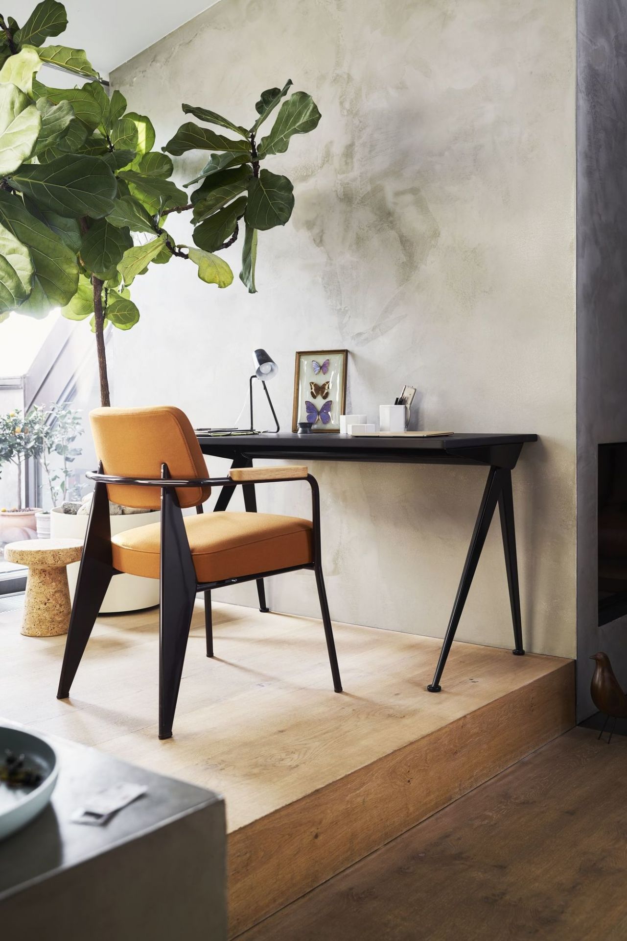 Fauteuil Direction Sessel von Vitra in orange am Schreibtisch, modernes Wohnambiente mit Zimmerpflanze.