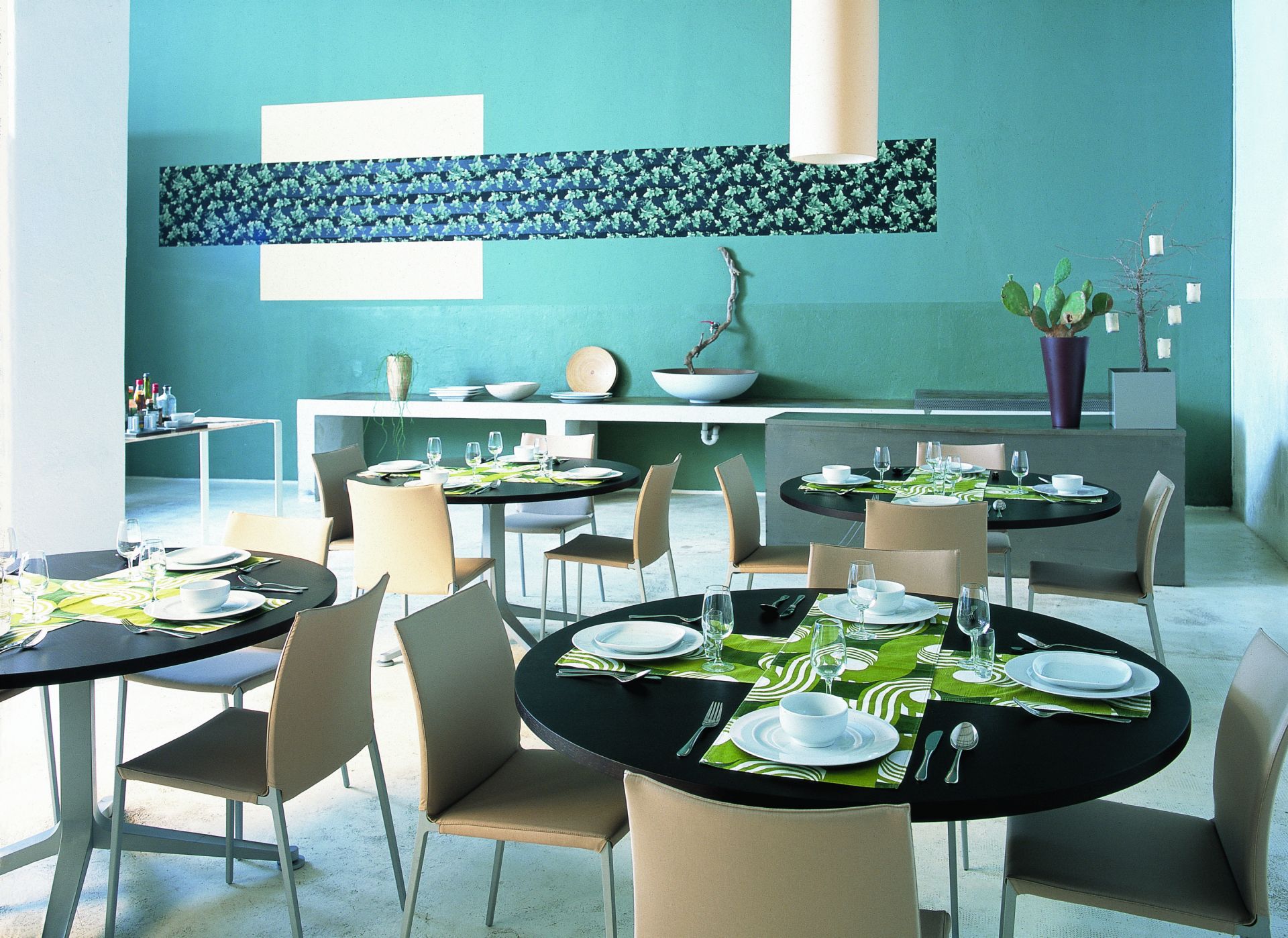 Innenaufnahme eines Restaurants mit mehreren Tischen und Zanotta Lia Stühlen ohne Armlehnen in Beige.