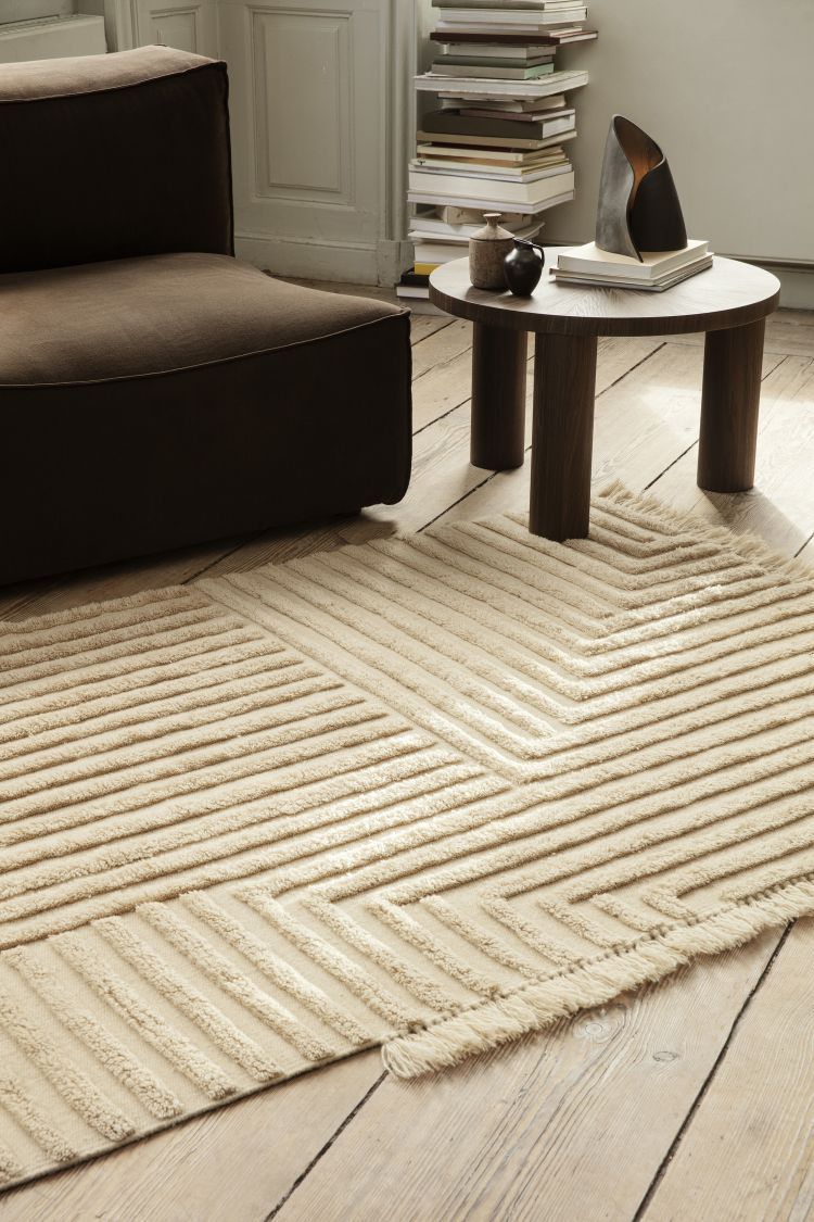 Nahaufnahme des beigen Kelim-Teppichs mit geometrischem Muster von Ferm Living im Wohnzimmer.