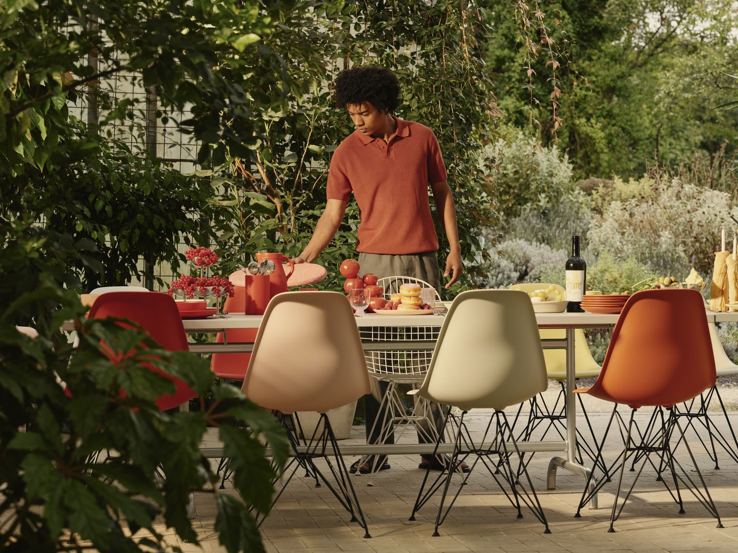 Eames Plastic Side Chair DSR Stuhl von Vitra an Esstisch im Garten. Designklassiker.