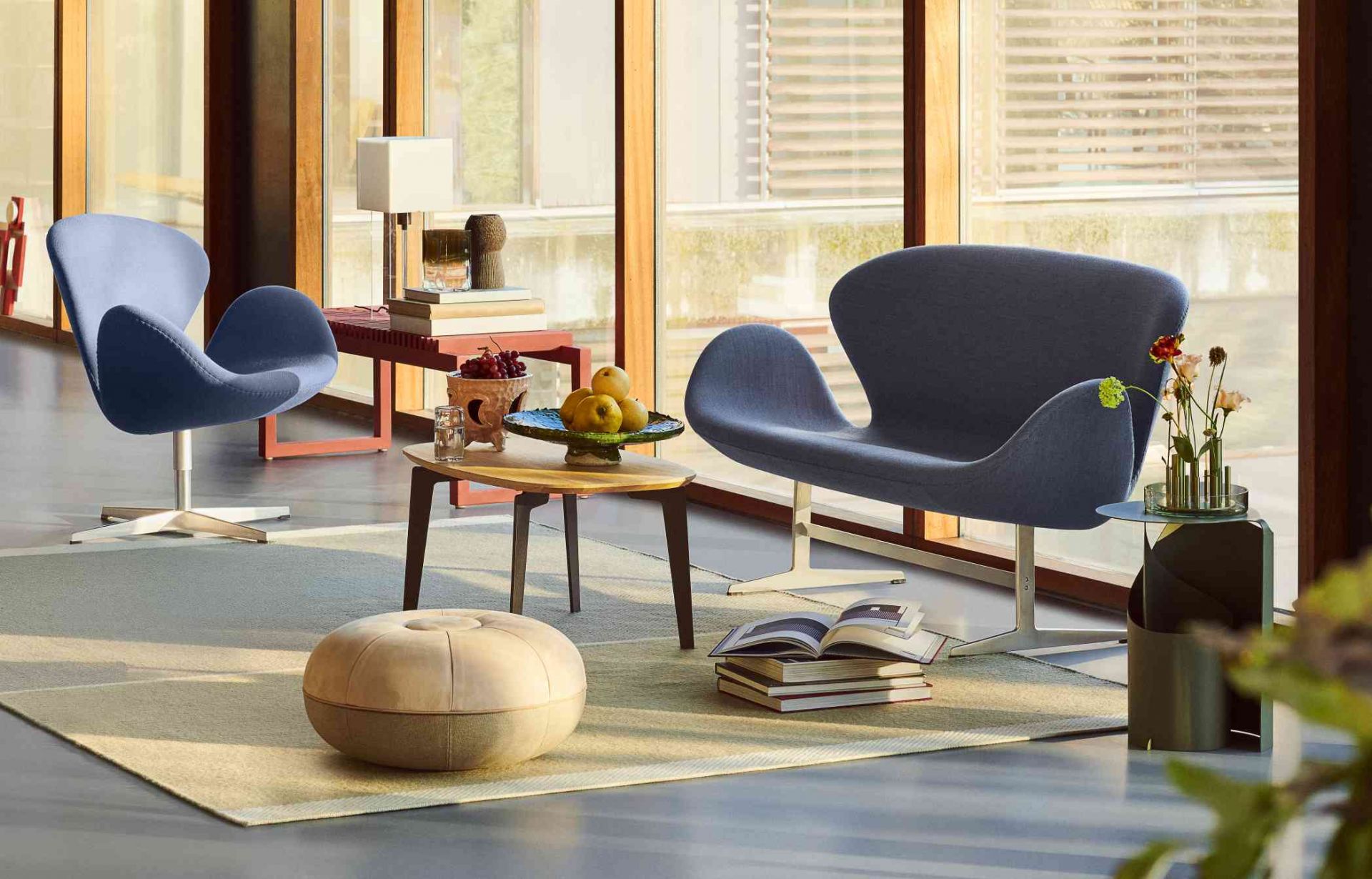 Blaues Swan Sofa von Fritz Hansen in stilvollem Wohnzimmer mit Designermöbeln und Tageslicht.