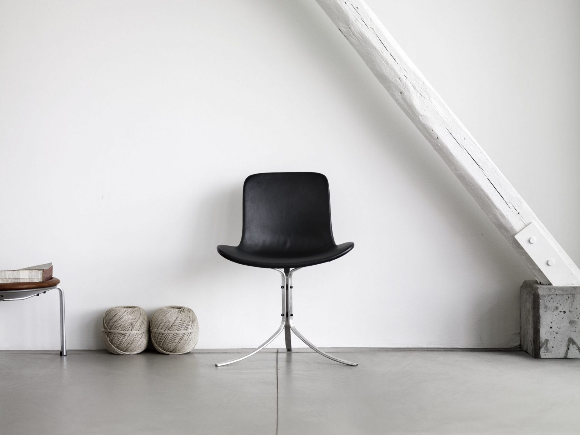 Schwarzer PK9 Stuhl von Fritz Hansen mit Lederbezug und filigranem Metallfuß vor weißer Wand.