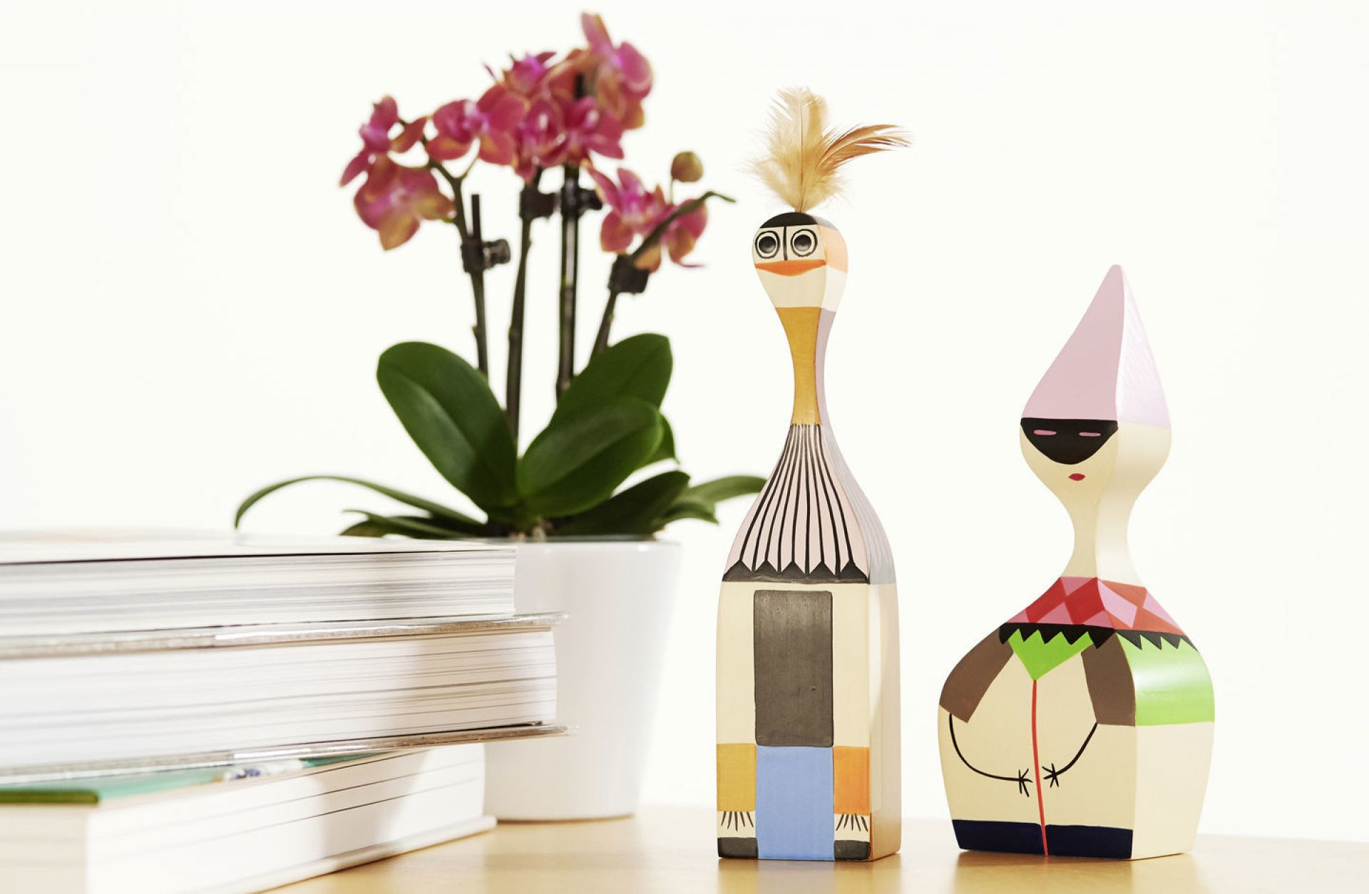 Holzfiguren von Vitra Wooden Dolls, dekorative Sammlerstücke im skandinavischen Design mit Orchidee und Büchern.