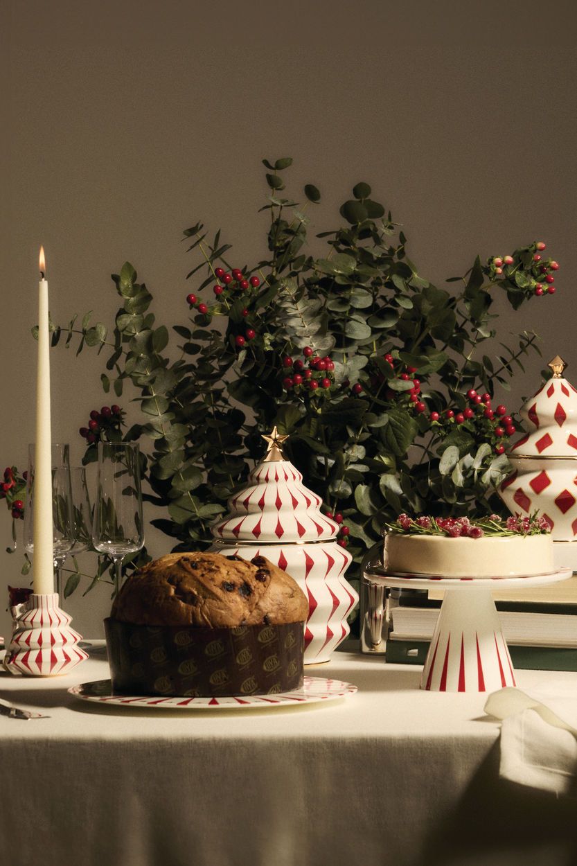 Festlicher Tisch mit Alessi Delight Etagere, Panettone, Kuchen, Kerze und weihnachtlicher Dekoration.