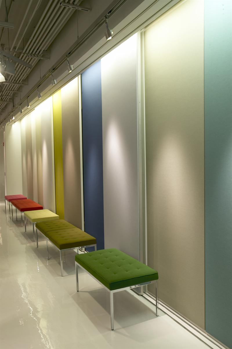 Reihe von Florence Bänken von Knoll International in verschiedenen Farben vor farbigen Wandpaneelen.