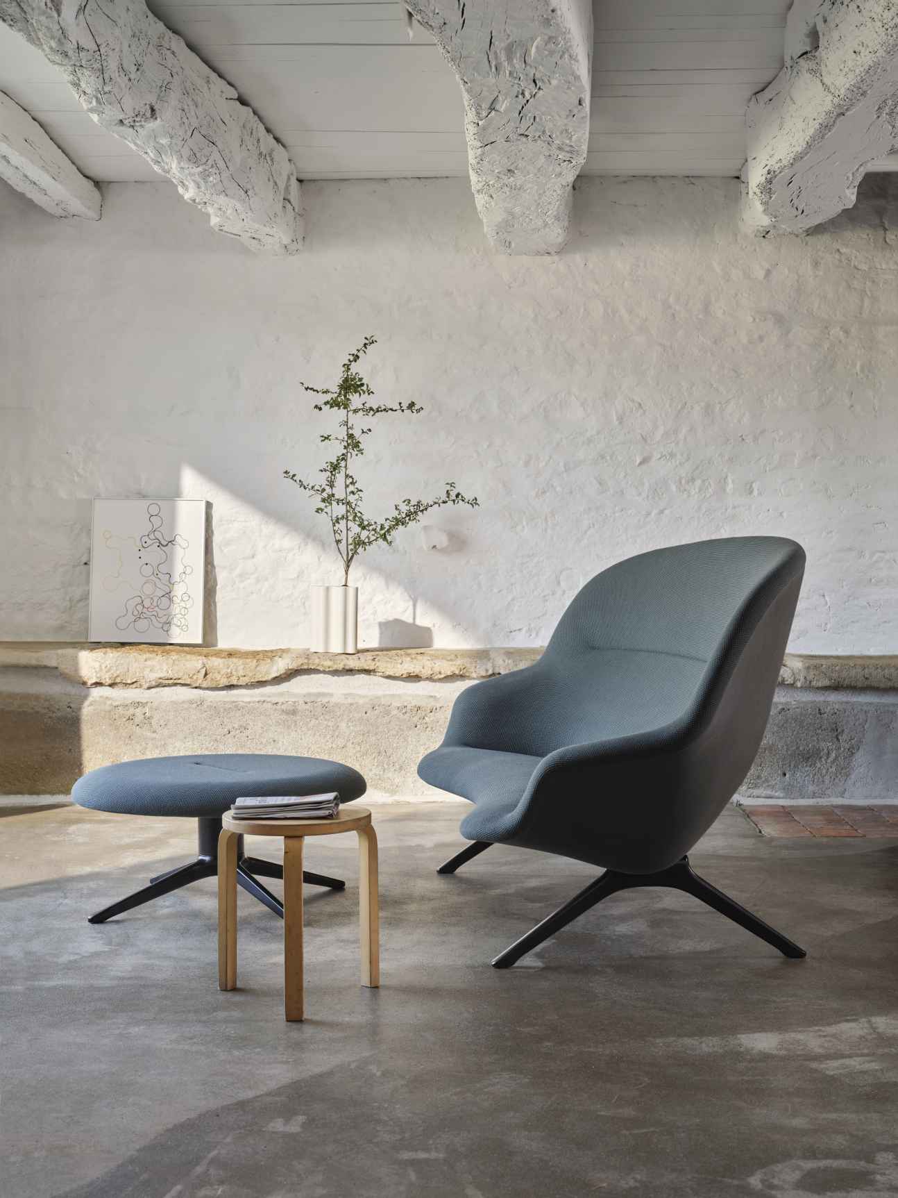 Abalon Sofa von Vitra mit passendem Hocker in grauem Stoffbezug und dunklem Fußkreuz.