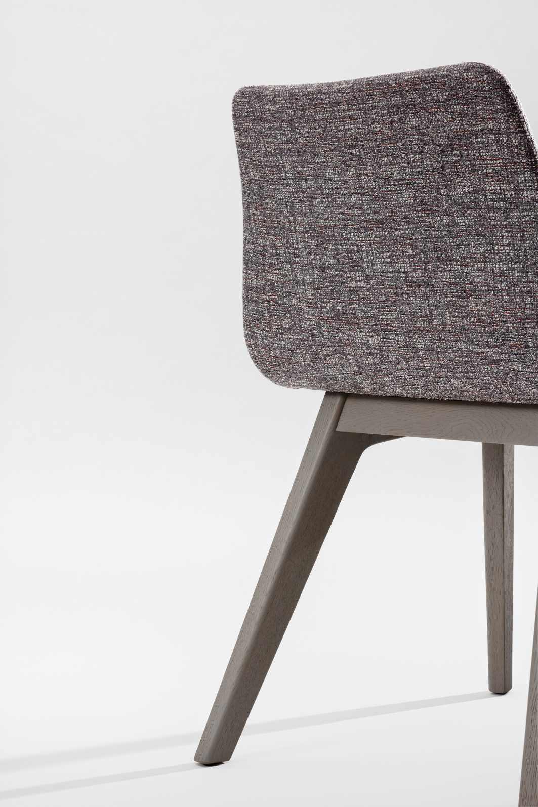 Detailaufnahme des Morph Plus Stuhls mit grauem Holzgestell und vollgepolstertem, meliertem Bezug.