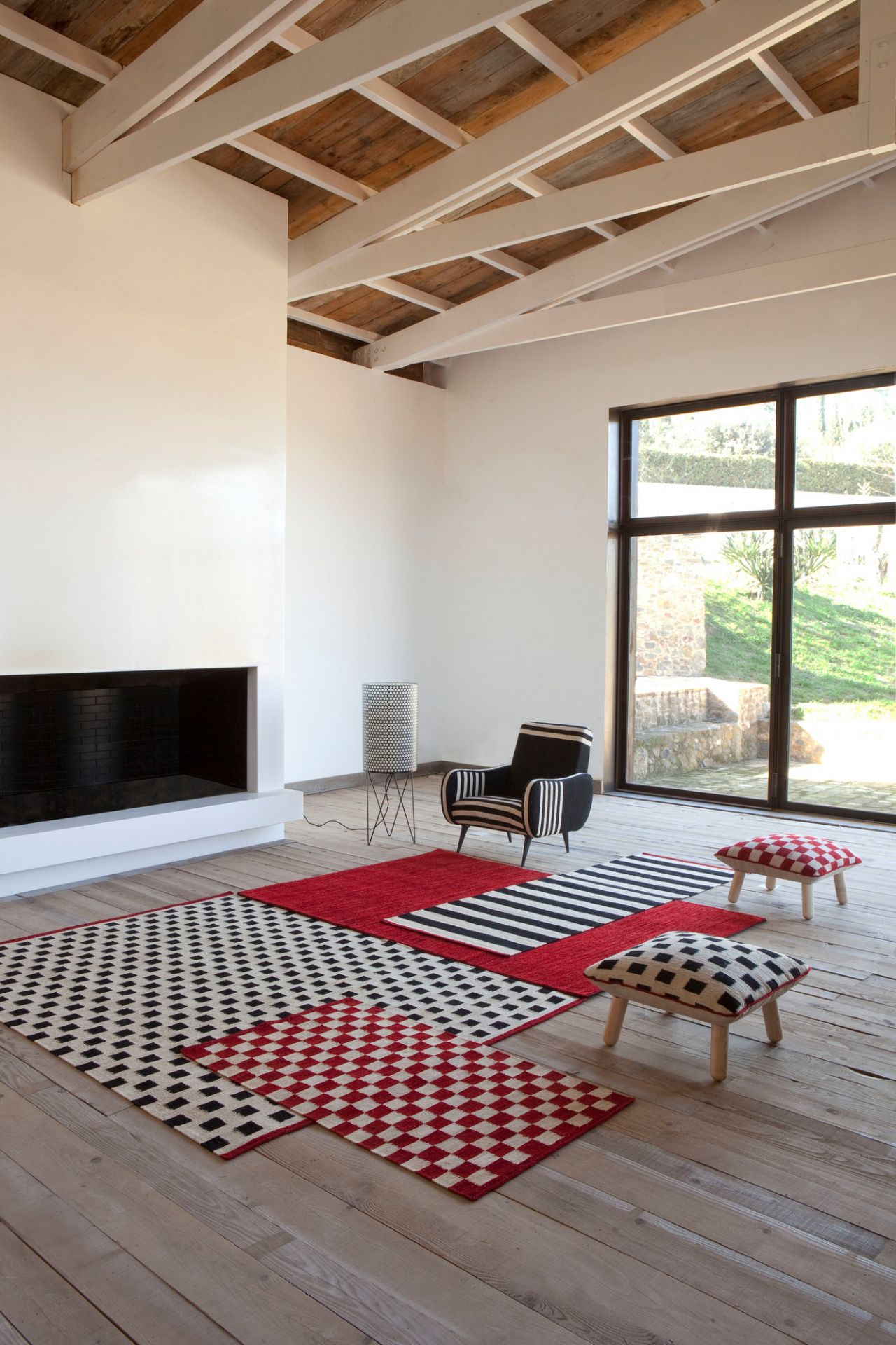 Moderner Wohnraum mit Nanimarquina Teppich "Mélange Pattern 3" in Rot, Schwarz und Weiß.