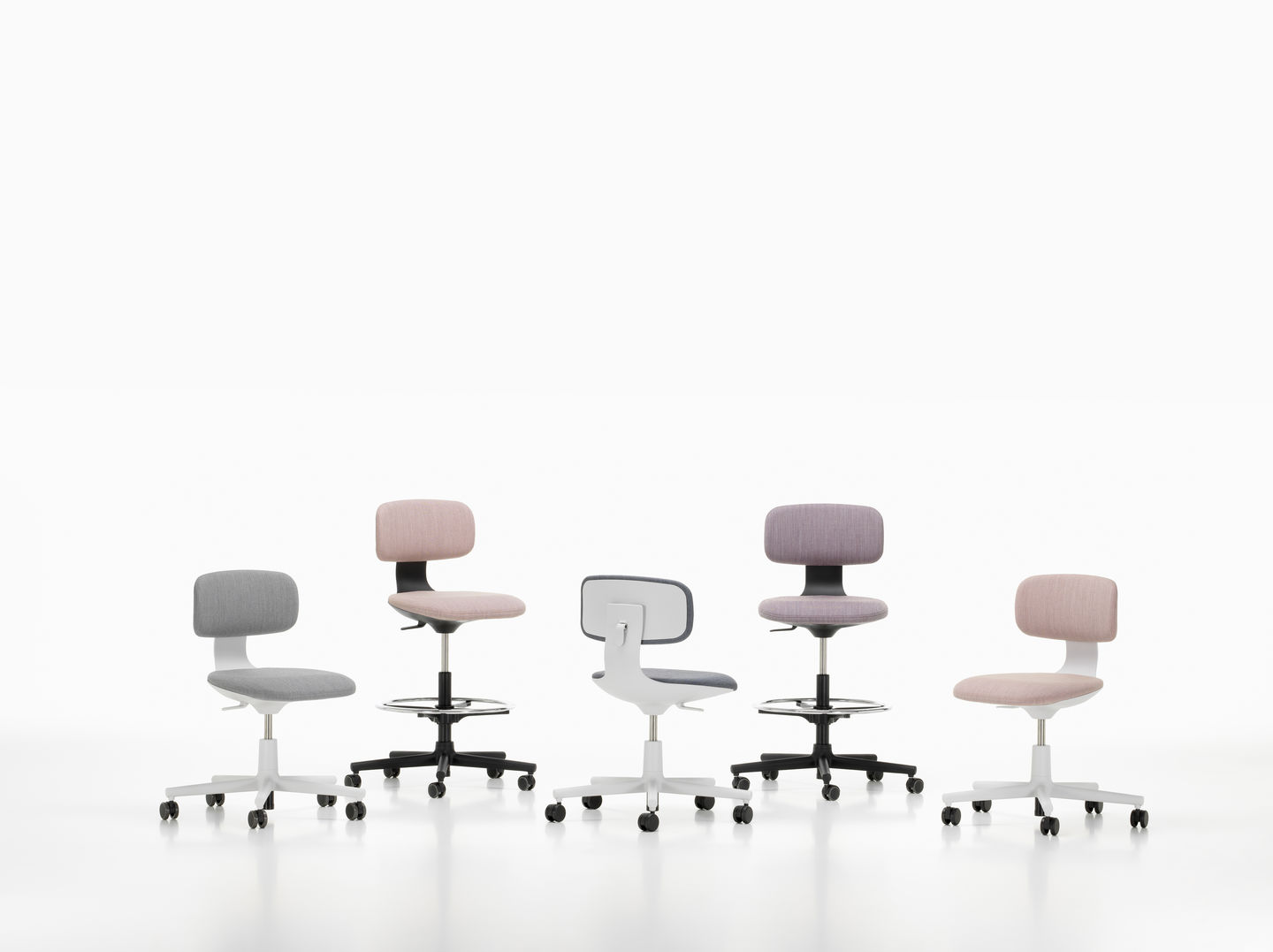 Vitra Rookie High Bürodrehstühle in Grau, Rosa und Lila mit Fußstütze und Rollen auf weißem Hintergrund.