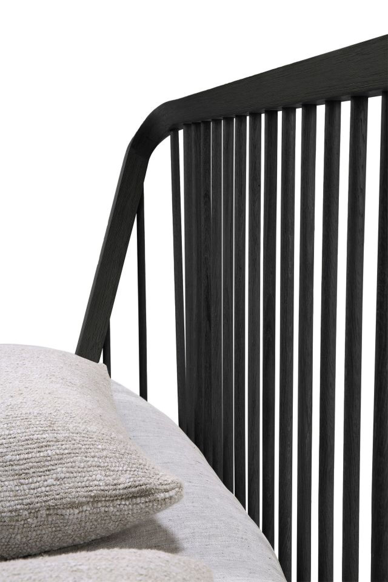 Detailaufnahme des Ethnicraft Spindle Bettes aus Eiche in Schwarz mit Lattenrost und Kissen.