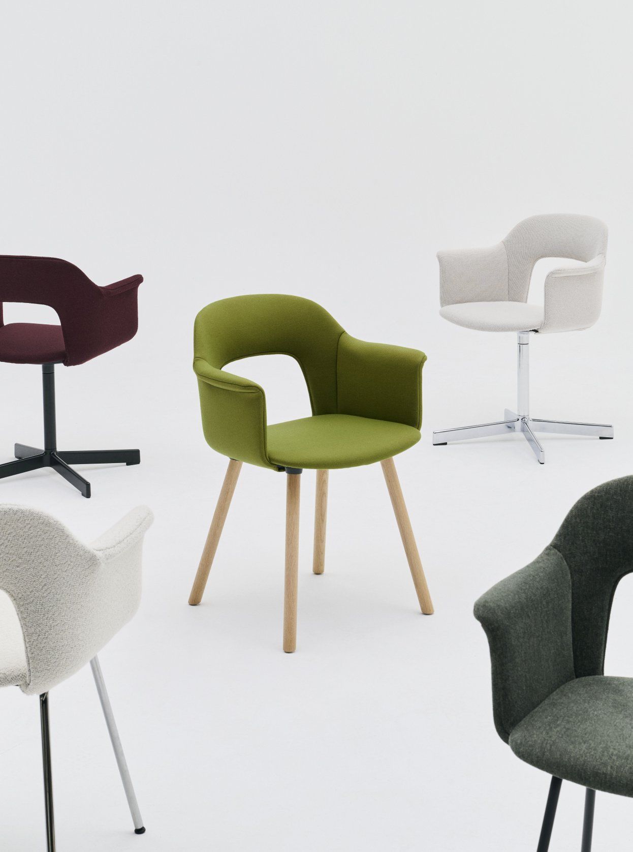Mehrere Hay Layout Armchair 221 Stühle in verschiedenen Farben und Ausführungen auf weißem Hintergrund.