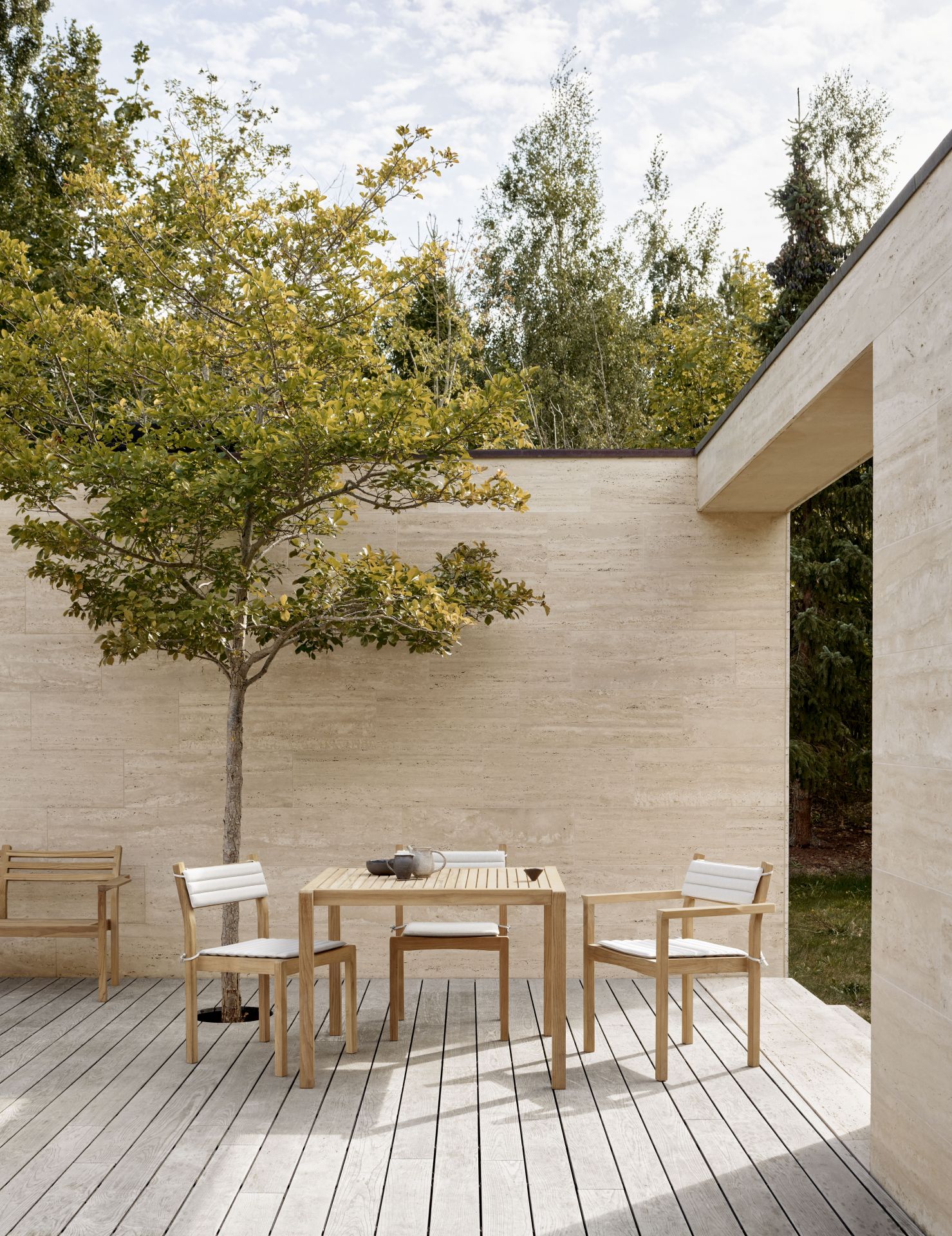 AH902 Carl Hansen Esstisch Outdoor aus Holz mit Stühlen und Sitzkissen auf Terrasse.