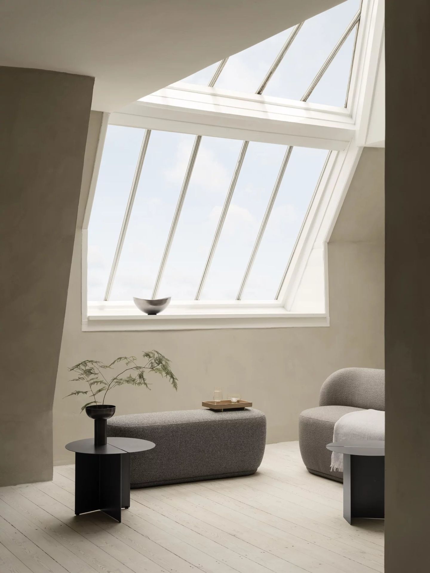Oru Beistelltisch von Blomus in Schwarz mit Pflanze im stilvollen, hellen Wohnzimmer.