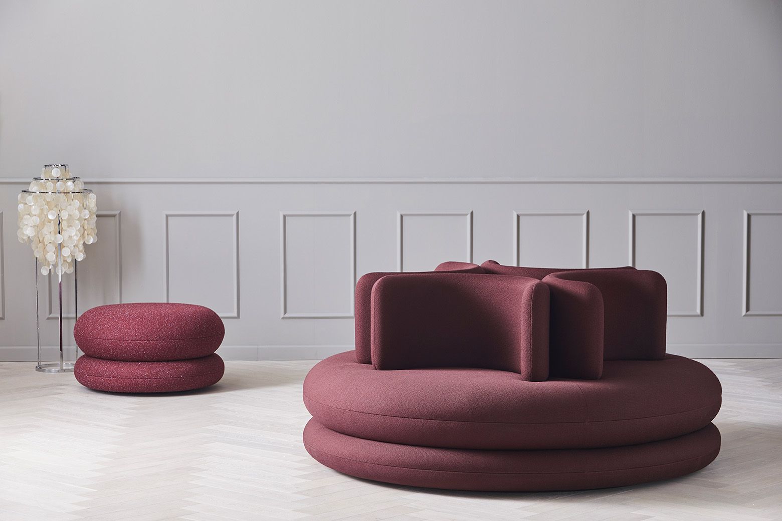 Burgunderrotes Verpan Sofa mit runden Formen und passendem Hocker. Moderne Wohnzimmer Einrichtung.