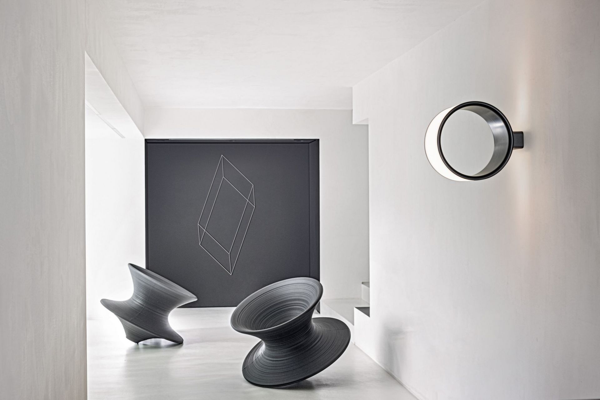 Helle, moderne Raumansicht mit Magis Lost Wandleuchte, runder Deckenlampe und Design-Skulpturen.
