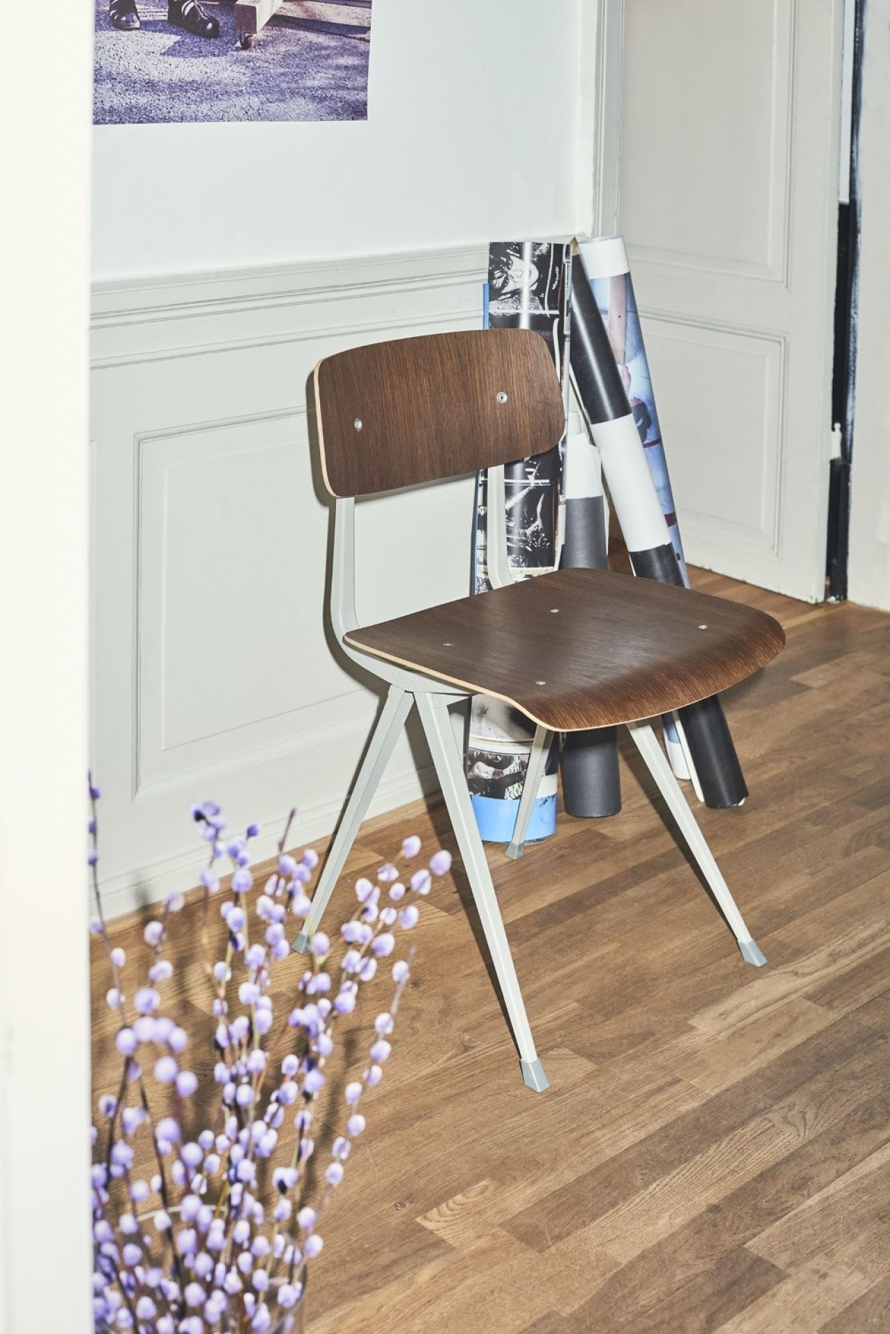 Hay Result Chair Stuhl mit Holz Sitzfläche und Rückenlehne, hellgraues Metallgestell vor weißer Wand.