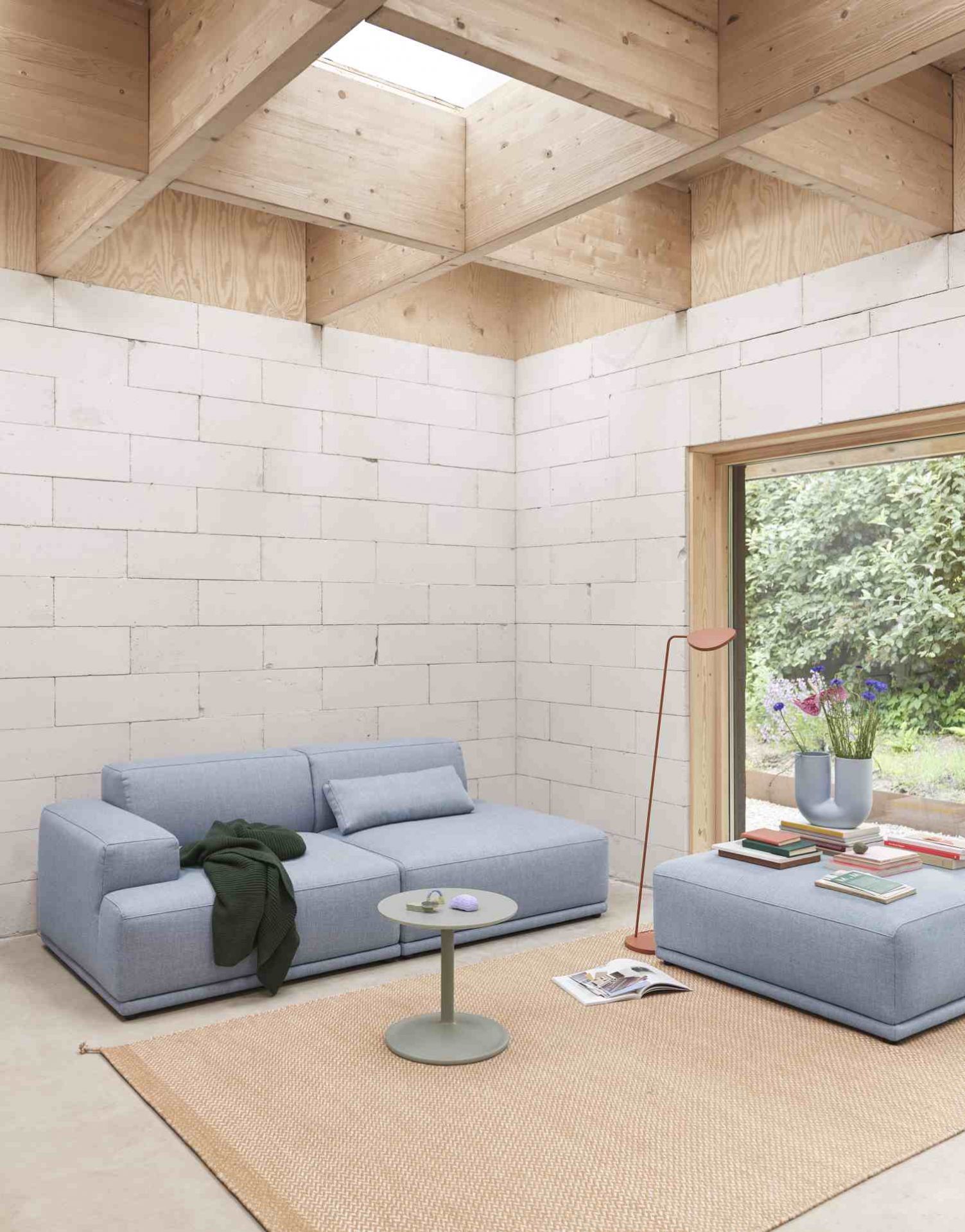 Helles Wohnzimmer mit blauem Connect Soft Sofa, Beistelltisch und passendem Hocker von Muuto.