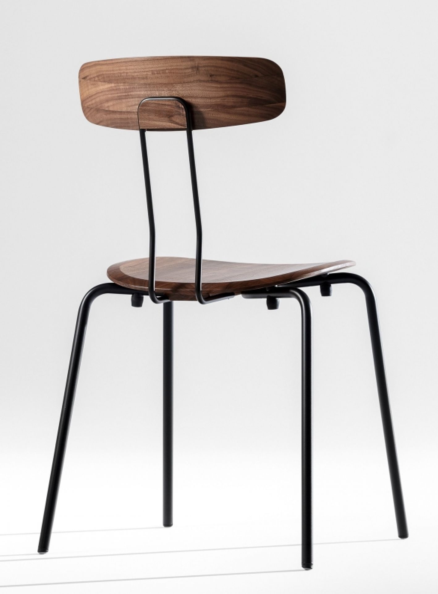 Okito Chair: Stuhl mit Holzschale und schwarzem Metallgestell, Ansicht von hinten. Designstuhl.