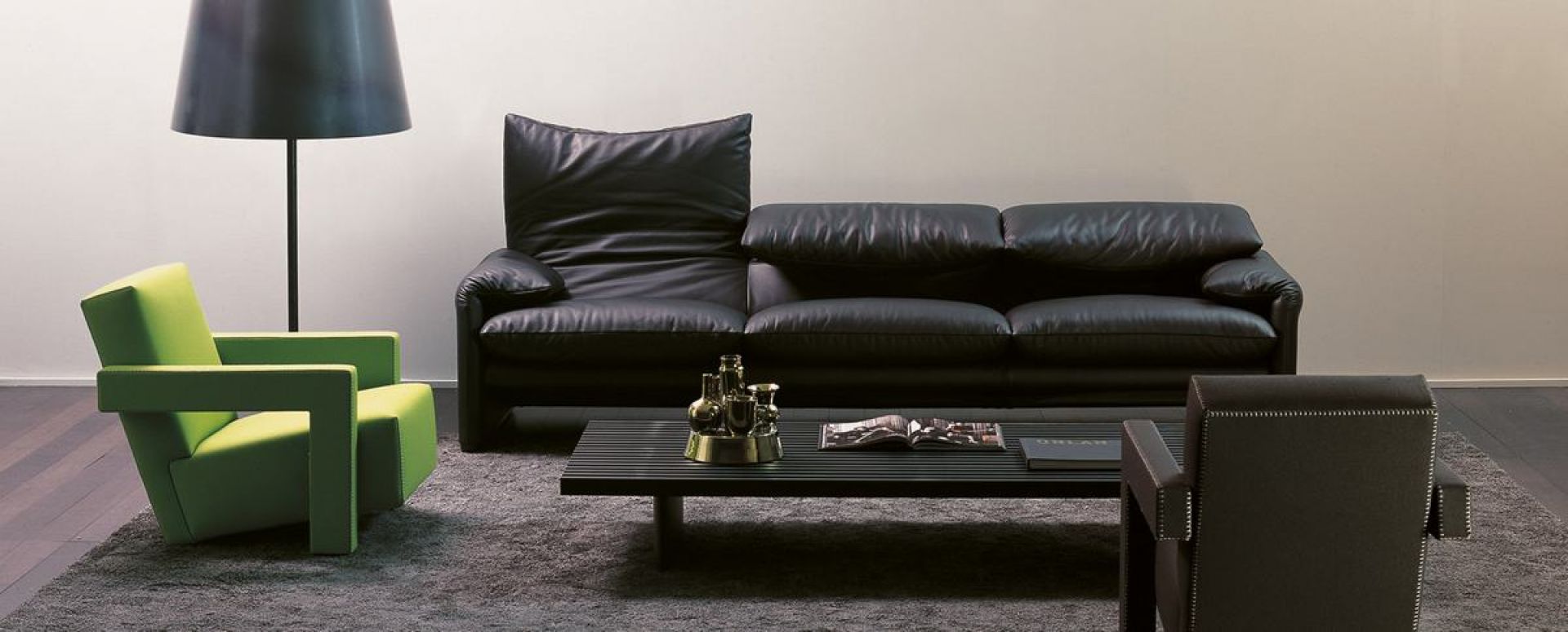 Schwarzes Maralunga Sofa von Cassina, ein Dreisitzer Ledersofa im modernen Wohnzimmer mit Sessel und Lampe.