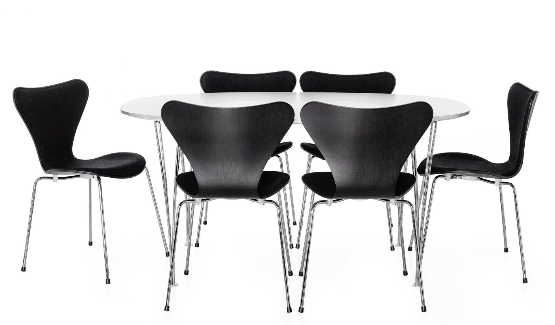 Fritz Hansen Super Elliptisch Esstisch mit schwarzen Stühlen und verchromten Beinen vor weißem Hintergrund.