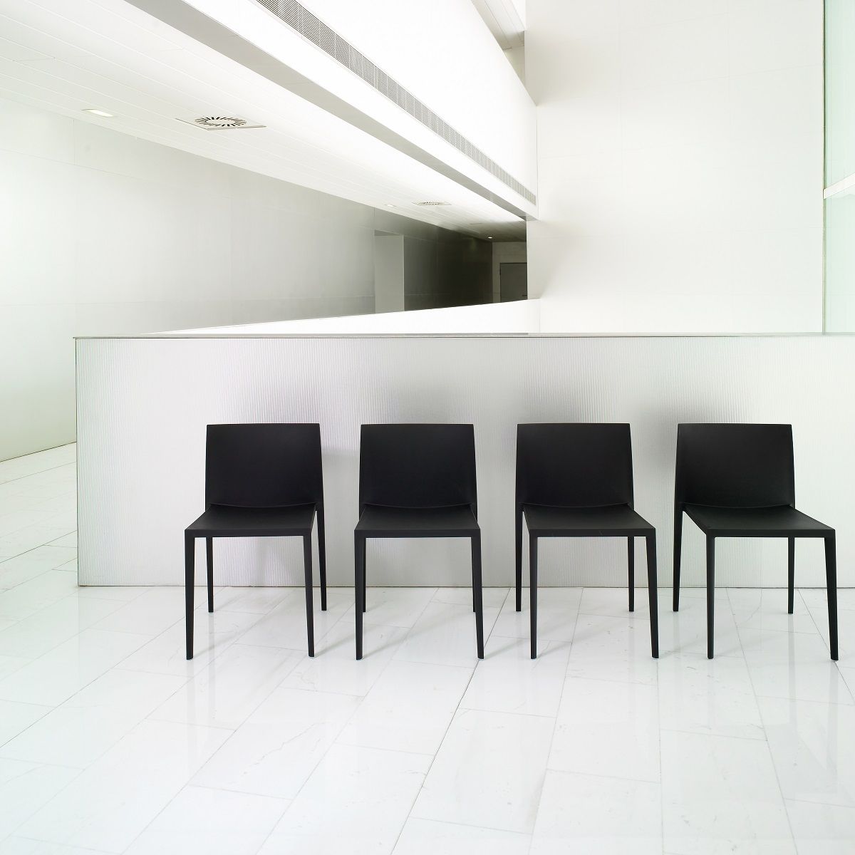 Vier schwarze Sail SI1245 Stühle von Andreu World, stapelbare Design-Stühle für Büro und Wartebereich.