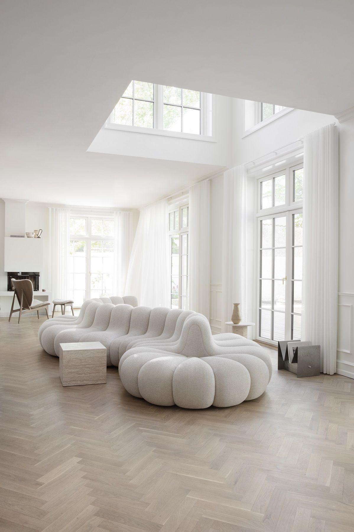 Helles Wohnzimmer mit modularem Sofa und Elephant Ottoman Hocker von NORR11 in Beige.