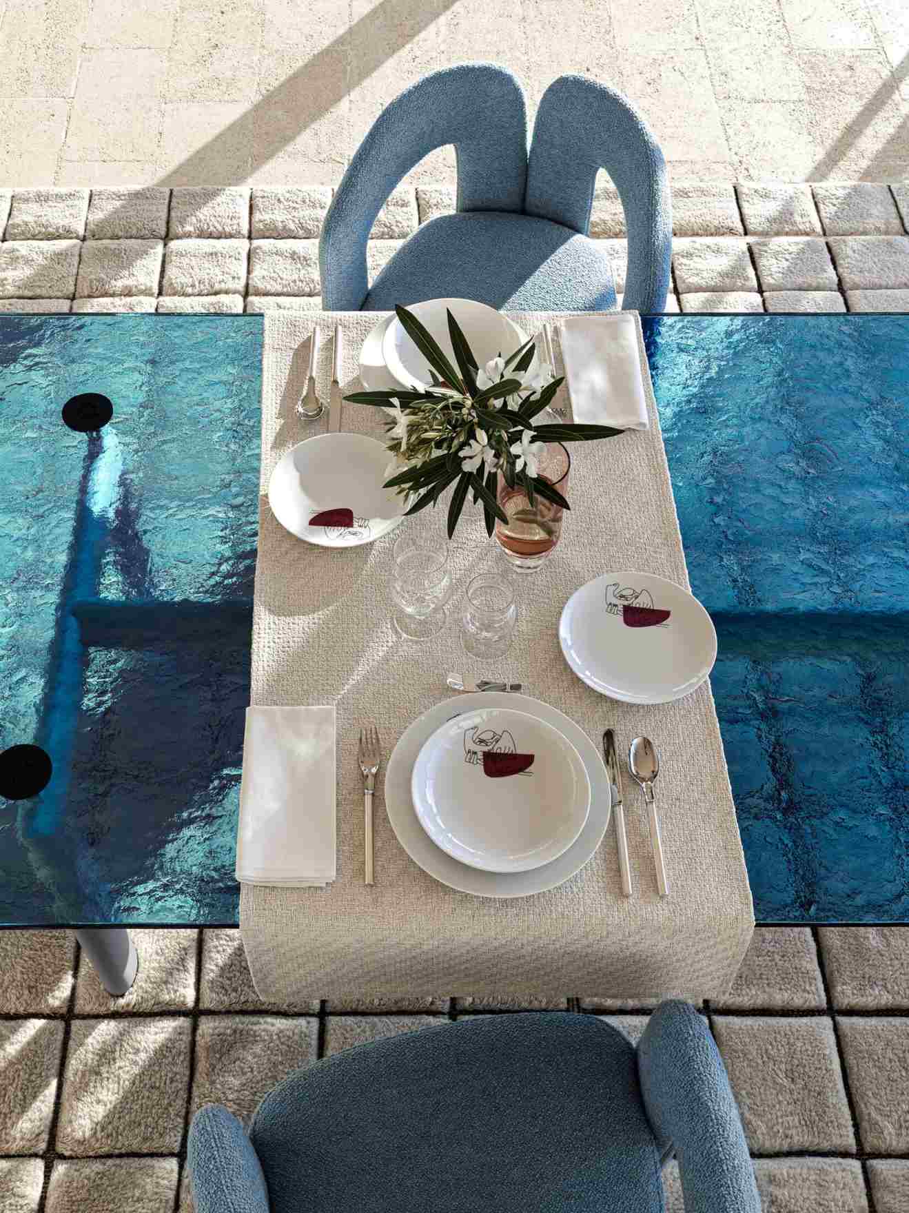 Esstisch mit Geschirr und blauen 562 Dudet Sesseln von Cassina, modernes Möbeldesign für Esszimmer.