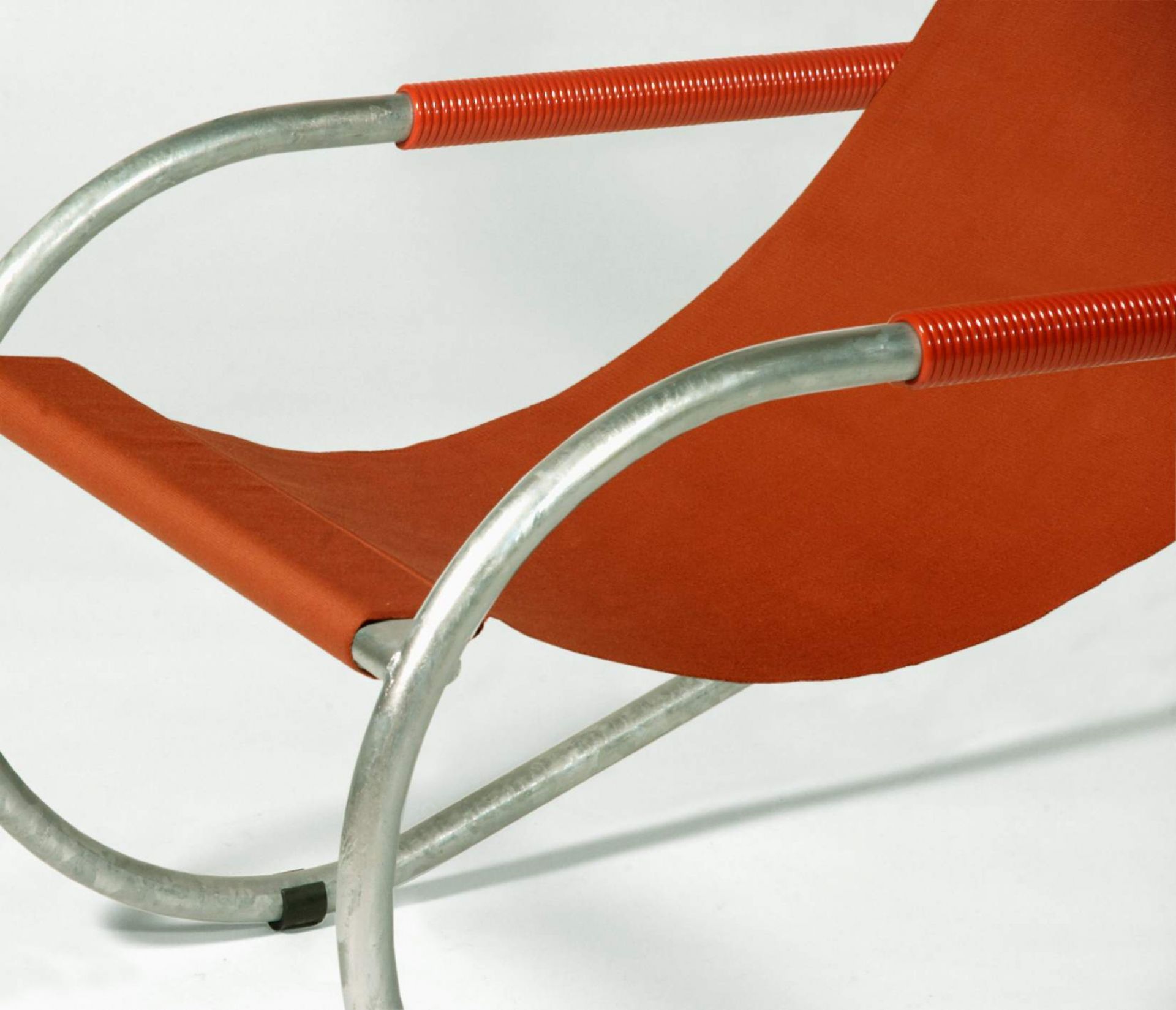 Nahaufnahme der Lido Liege mit orangefarbenem Stoffbezug und silberfarbenem Metallgestell, modernes Möbeldesign.