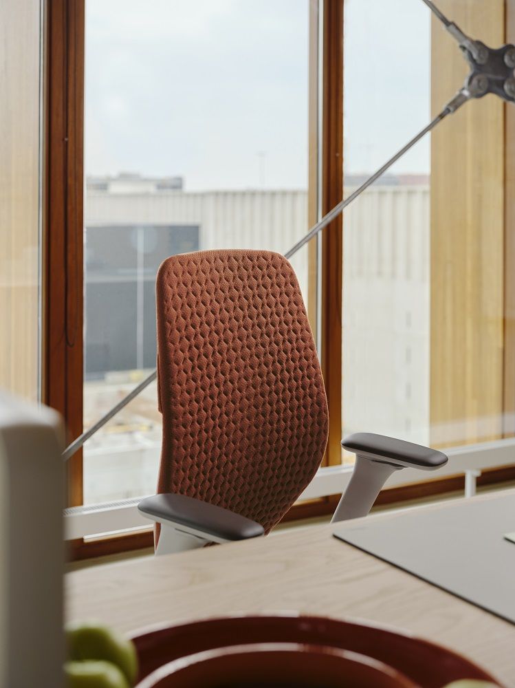 Nahaufnahme des Vitra ACX Soft Bürodrehstuhls in Braun vor einem Fenster, ergonomischer Bürostuhl für Komfort.