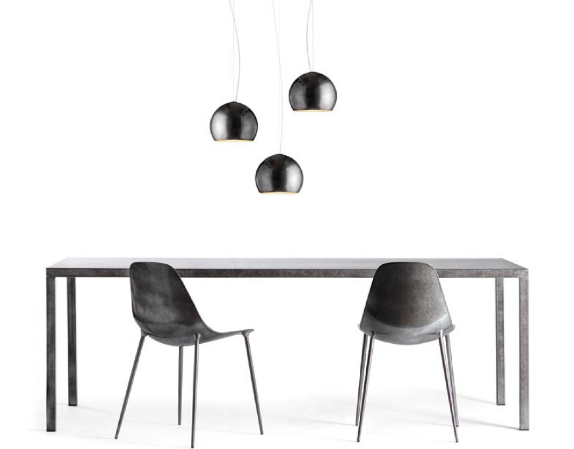ILtavolo Tisch von Opinion Ciatti mit zwei Stühlen und drei Hängelampen im modernen Design.