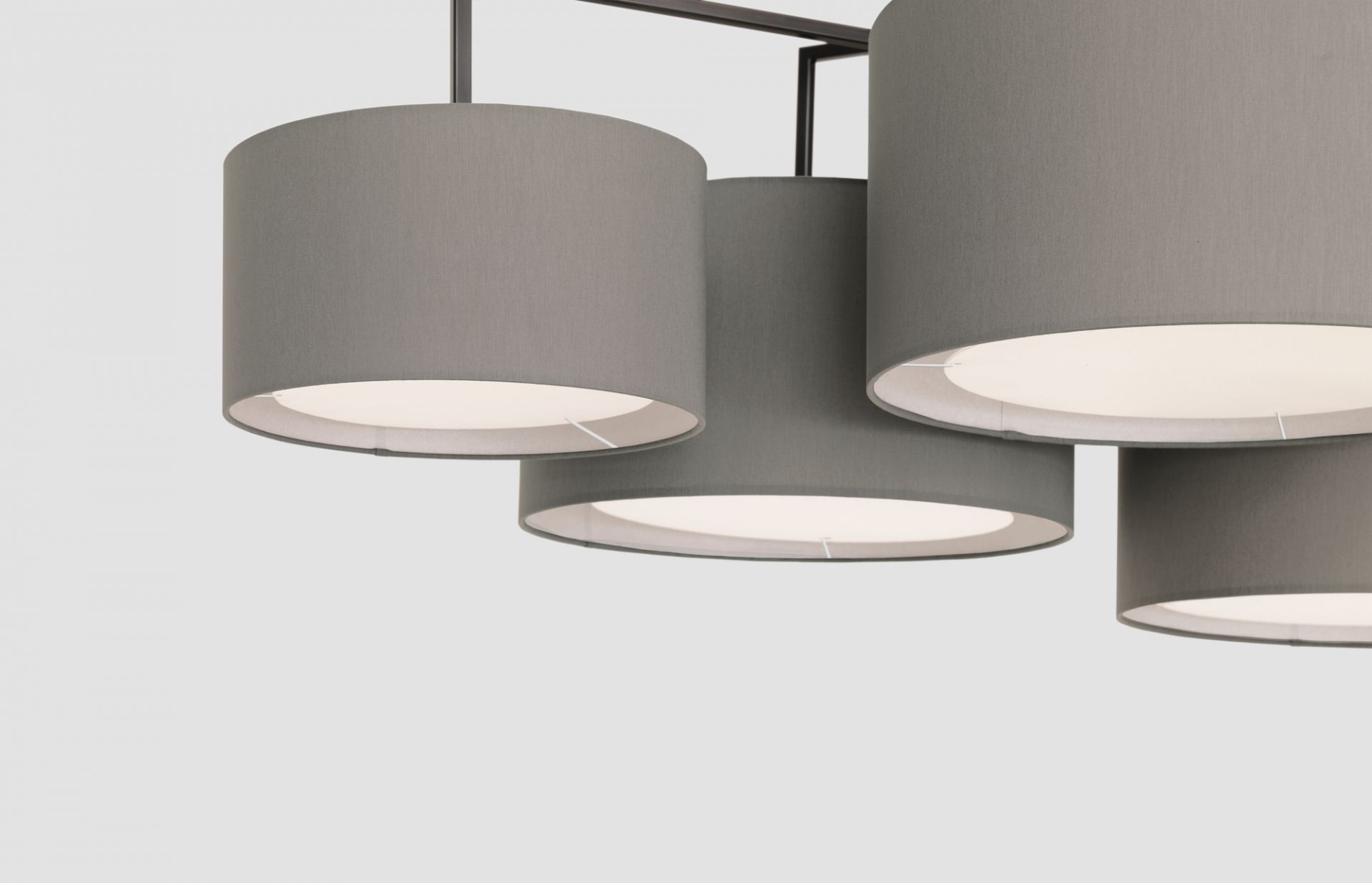 Nahaufnahme der Noon 5 LED Leuchte in Warmgrau mit Stoffschirmen und warmem Licht.
