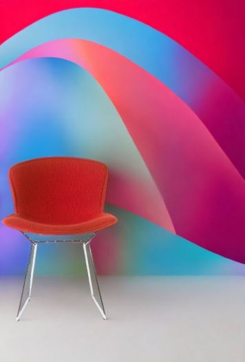 Bertoia Stuhl mit roter Vollpolsterung und verchromtem Drahtgestell vor farbenfrohem Hintergrund. Designklassiker von Knoll International.